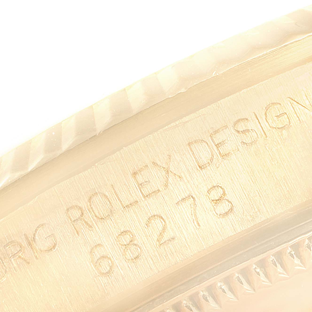 The image shows a close-up of the serial number and design engraving on the case of a Rolex President 69278 Women
s Yellow Gold Champagne Dial 69278 Women
s Yellow Gold Champagne Dial model.