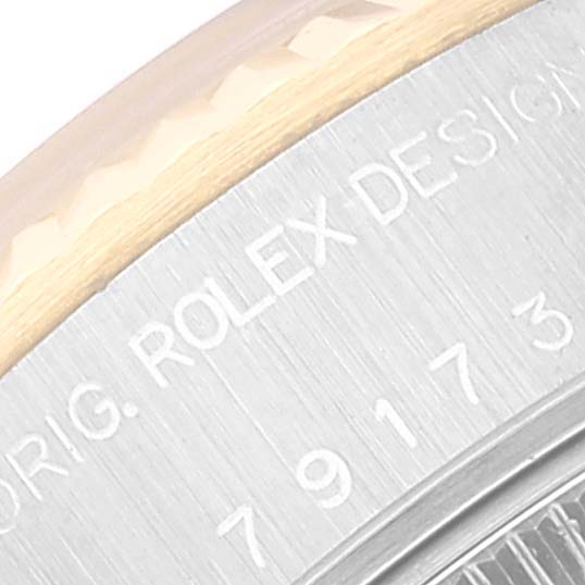 Close-up of the Rolex Datejust 79173 Women's Steel and Gold (two tone) Grey Dial 79173 Women's Steel and Gold (two tone) Grey Dial's bezel and case, showing part of the serial number and "ROLEX DESIGN" engraving.