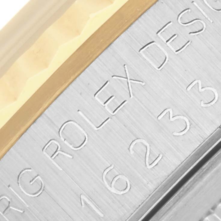 The image shows a close-up of the case detailing on a Rolex Datejust 16233 Men's Steel and Gold (two tone) White Dial 16233 Men's Steel and Gold (two tone) White Dial, featuring engraved text and part of the bezel.
