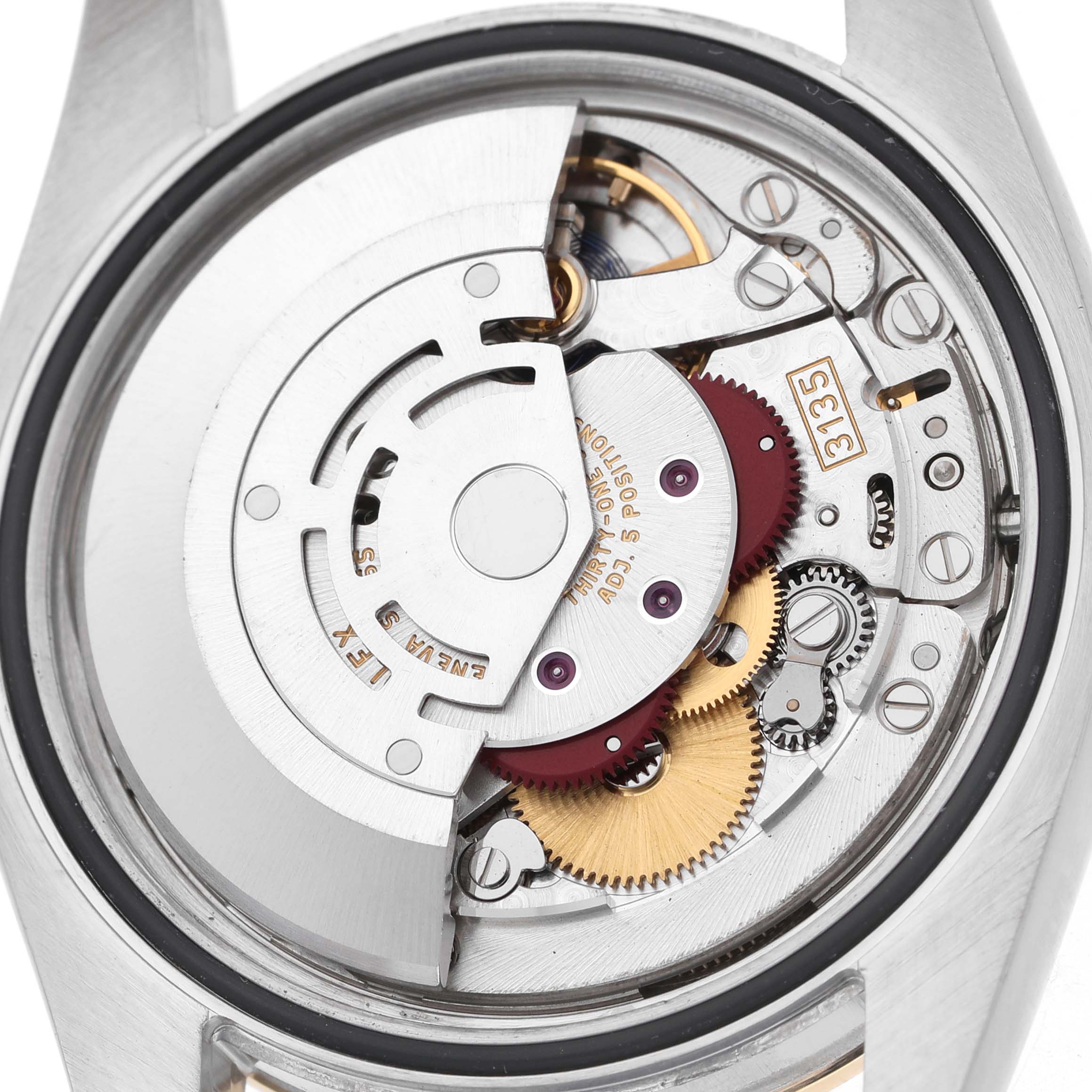 The image shows the movement components of a Rolex Datejust 116243 Men's Steel and Gold (two tone) Mother of Pearl Dial watch from a back angle, highlighting gears and the rotor.