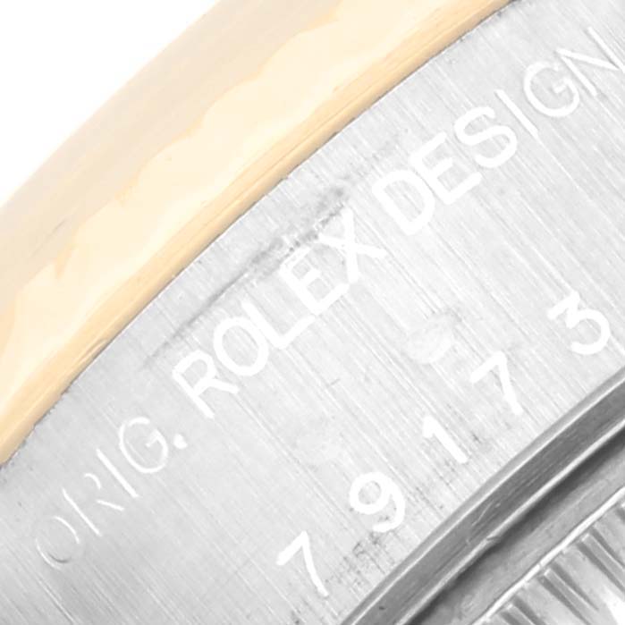 This close-up image of the Rolex Datejust 79173 Women's Steel and Gold (two tone) White Dial 79173 Women's Steel and Gold (two tone) White Dial watch shows the engraved edge of the case with "Original Rolex Design" and part of the model number.