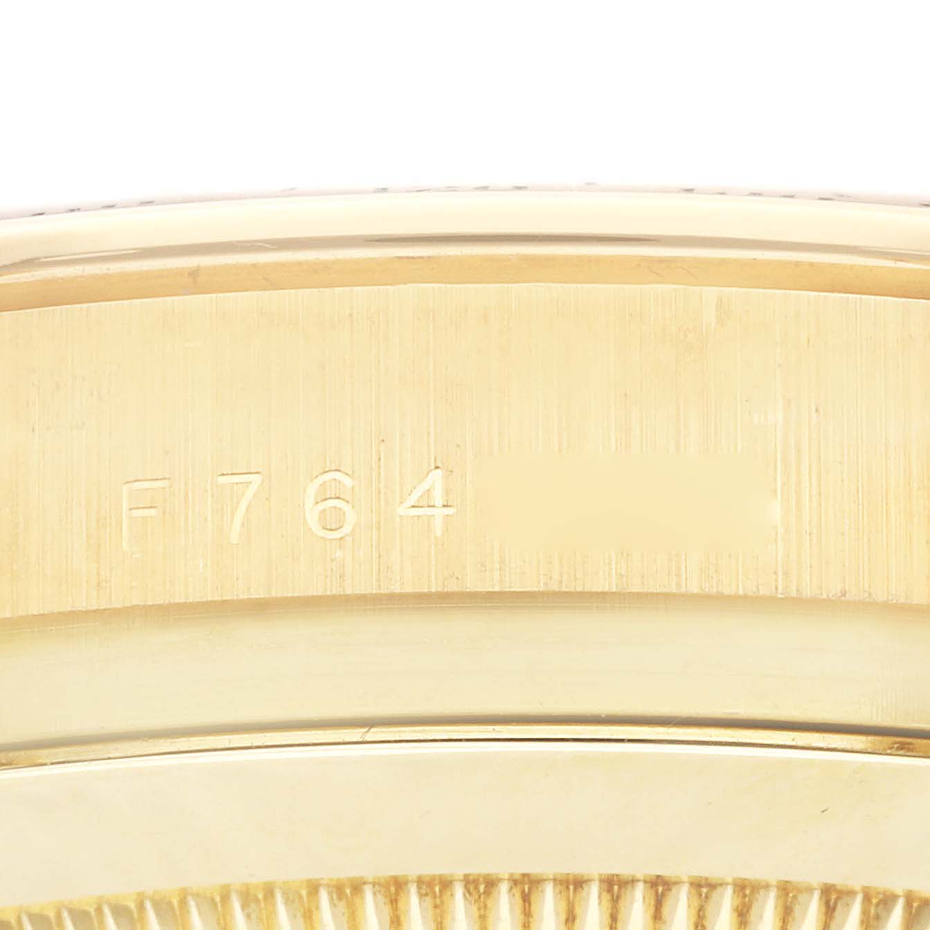 This is a close-up shot of the serial number engraving on the side of a Rolex Daytona 116528 Men's Yellow Gold Mother of Pearl Dial 116528 Men's Yellow Gold Mother of Pearl Dial watch bezel.
