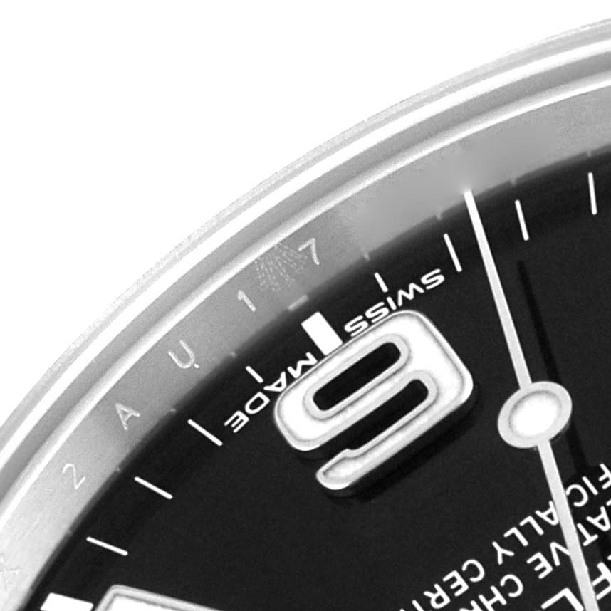 This close-up image of the Rolex Explorer 214270 Men
s Stainless Steel Black Dial 214270 Men
s Stainless Steel Black Dial watch shows part of the dial, including the "9" numeral, "Swiss Made," and part of the minute markers.