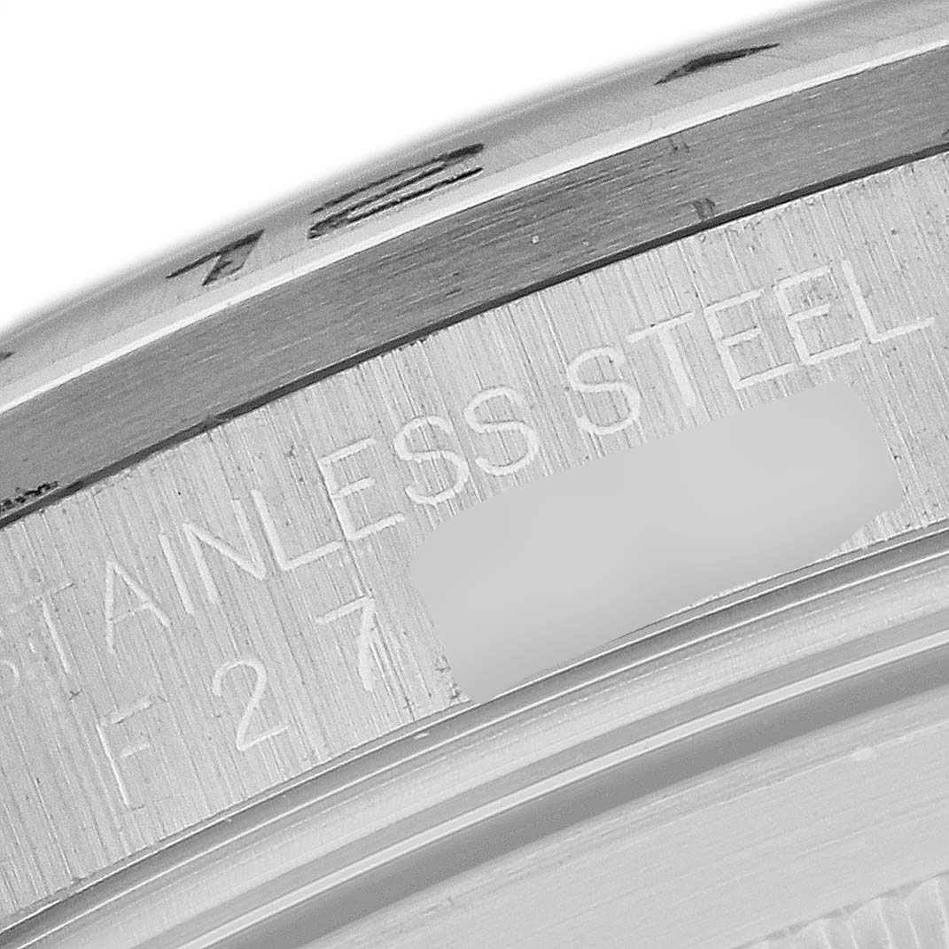 This close-up image of a Rolex Explorer 16570T Men's Stainless Steel White Dial 16570T Men's Stainless Steel White Dial watch shows part of the stainless steel case with engraved text.