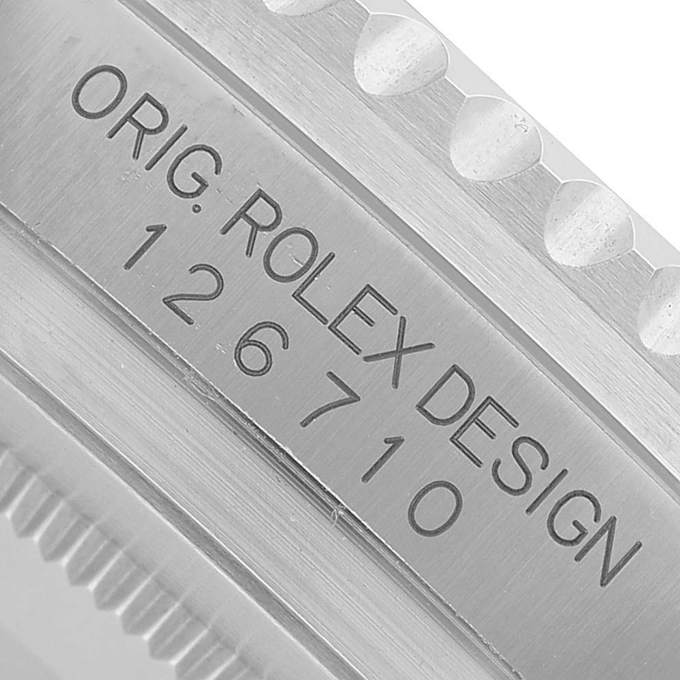 The image shows a close-up angle of a Rolex GMT-Master 126710GRNR Men's Stainless Steel Black Dial model engraving on the watch's edge.