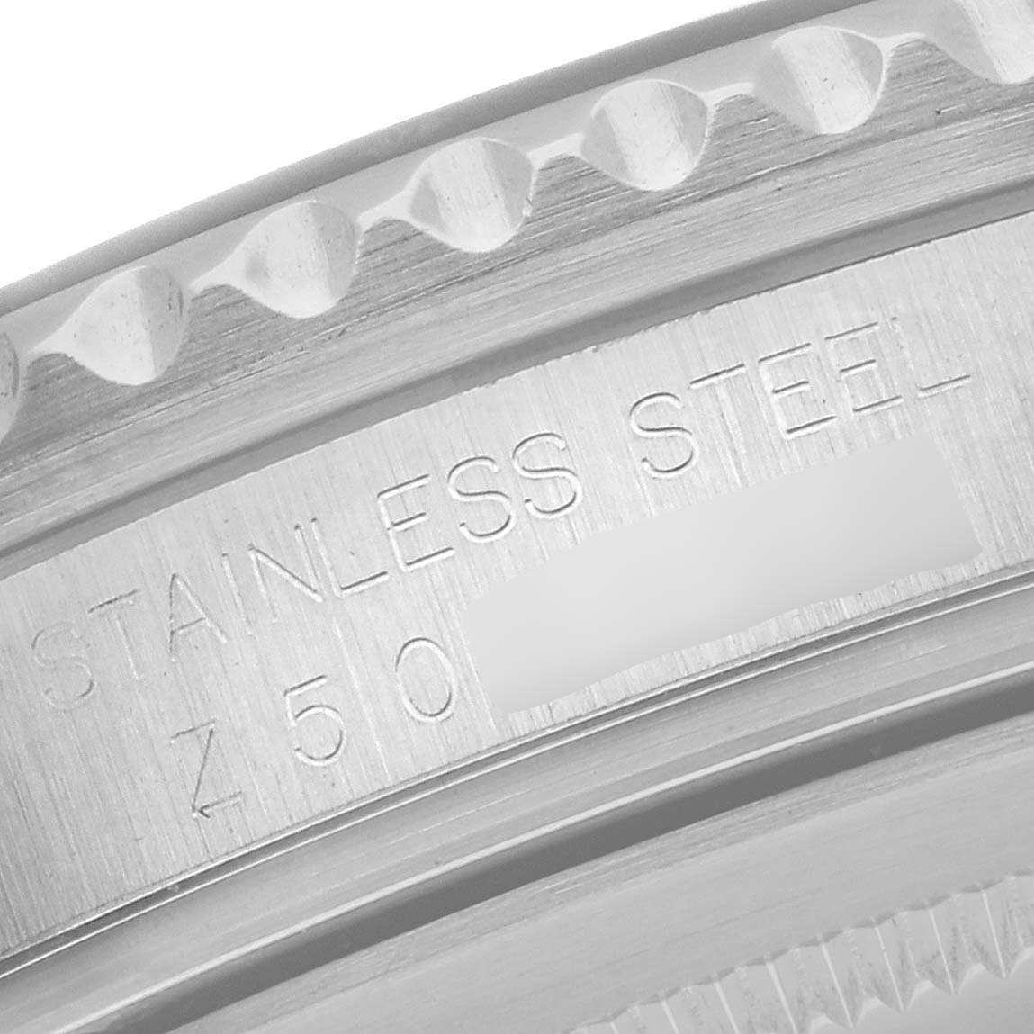 This close-up image shows the stainless steel engravings on the edge of a Rolex GMT-Master 16710 Men's Stainless Steel Black Dial 16710 Men's Stainless Steel Black Dial watch case.