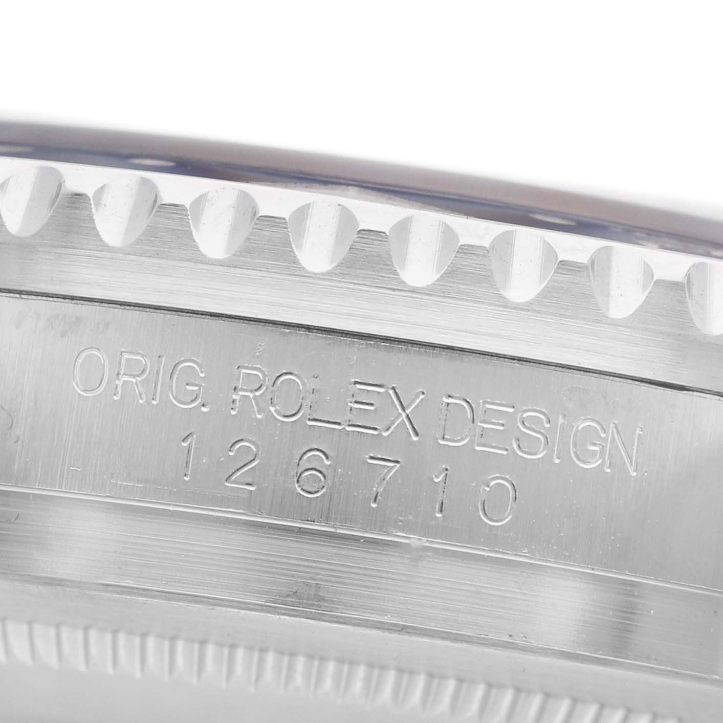 The image shows a close-up of the side of a Rolex GMT-Master 126710BLRO Men's Stainless Steel Black Dial watch, focusing on the engraved model number and design text.