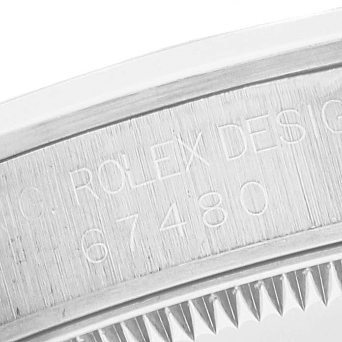 The image shows a close-up of the serial number engraving on the case of a Rolex Mid-Size 67480 Women
s Stainless Steel Blue Dial 67480 Women
s Stainless Steel Blue Dial model watch, model number 67480.