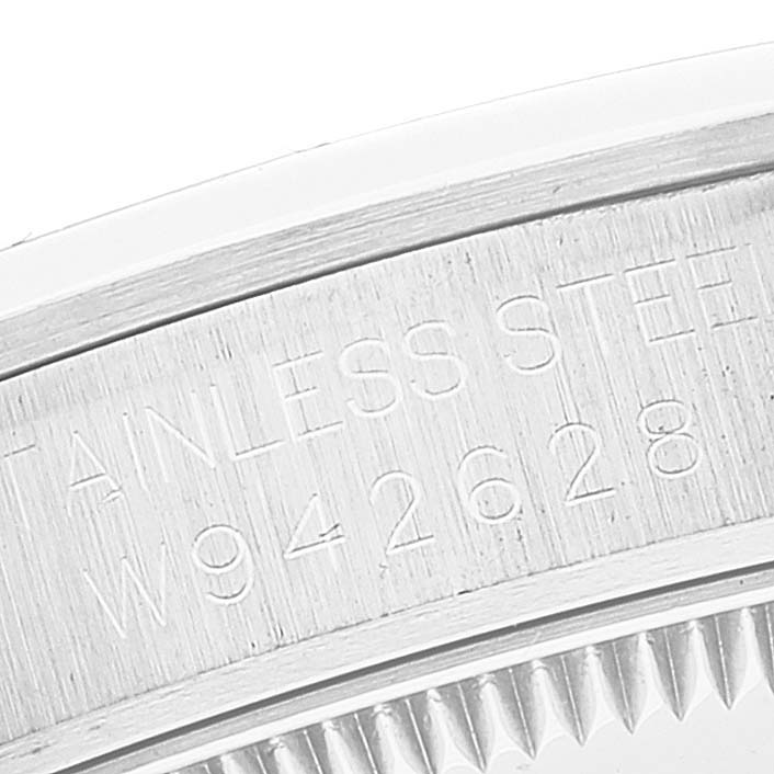 The image shows a close-up of the case back engraving on a Mid-Size Rolex watch, displaying "STAINLESS STEEL" and a serial number.