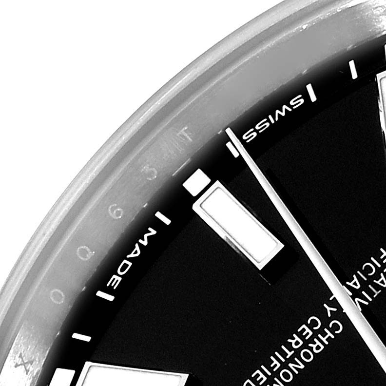 This close-up image of a Rolex Oyster Perpetual 114300 Men
s Stainless Steel Black Dial 114300 Men
s Stainless Steel Black Dial watch shows part of the dial, hour markers, hands, and the "Swiss Made" text.
