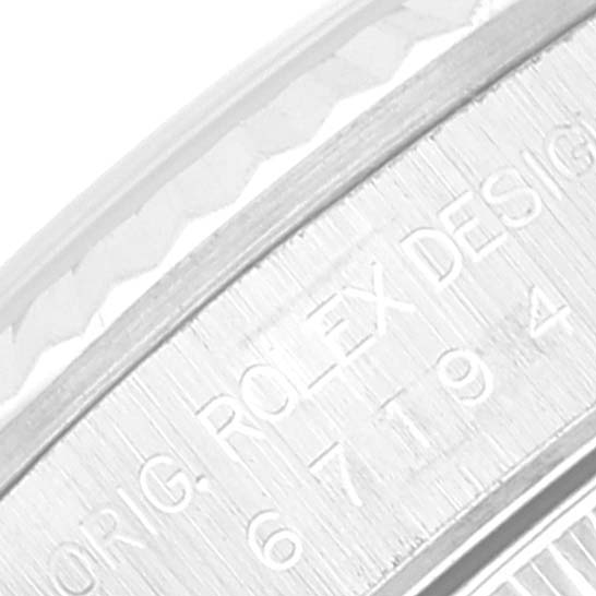This close-up image shows the engraved branding and serial number on the caseback edge of a Rolex Oyster Perpetual 67194 Women's Stainless Steel Blue Dial 67194 Women's Stainless Steel Blue Dial watch.
