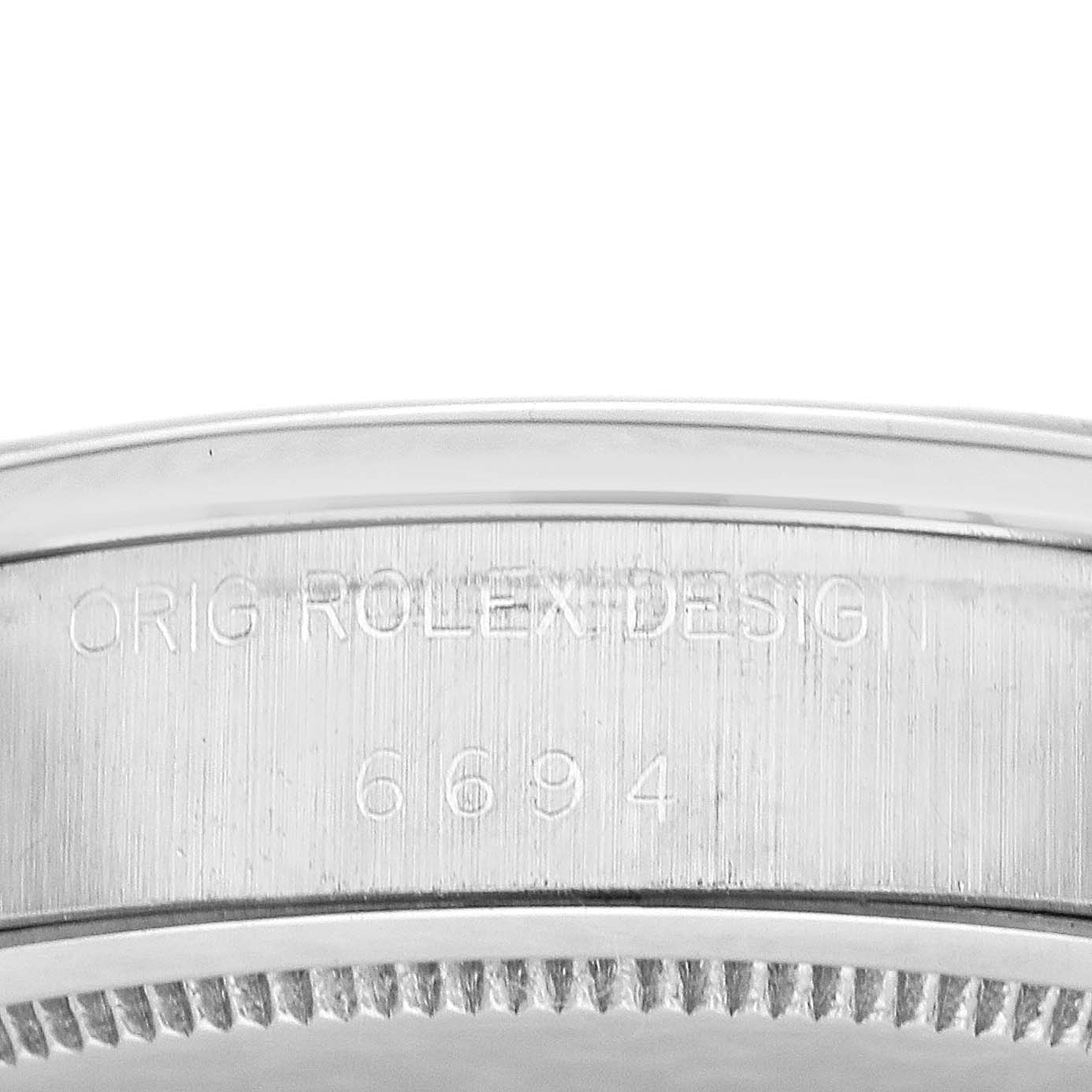 The image shows a close-up of the side of the Rolex Date 6694 Men's Stainless Steel Black Dial 6694 Men's Stainless Steel Black Dial watch case with model number and design engraving.