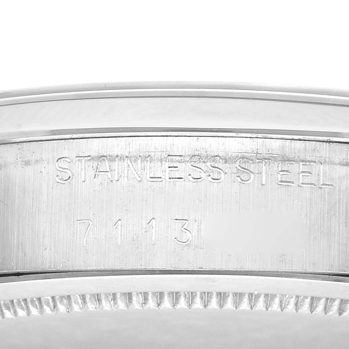 The image shows a close-up of the Rolex Date 6694 Men's Stainless Steel Black Dial 6694 Men's Stainless Steel Black Dial model's stainless steel case, focusing on the engraved details from a side angle.