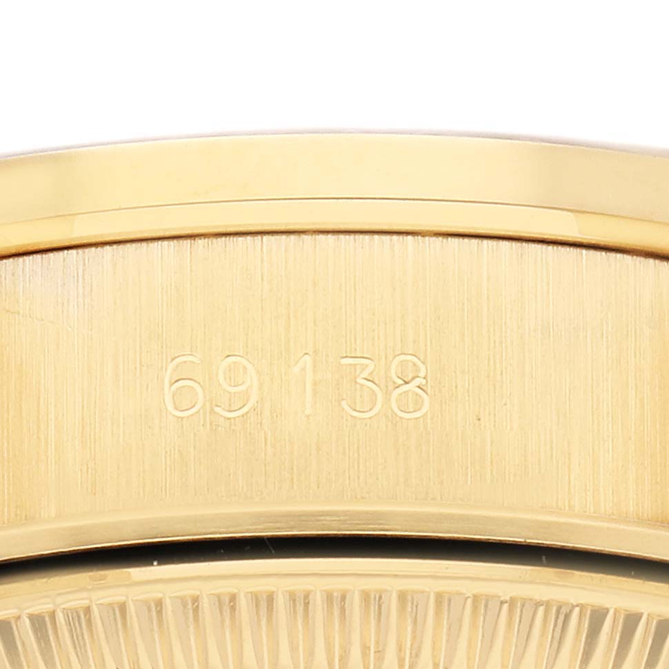 The image shows a close-up of the President model by Rolex, focusing on its gold bezel and the engraved numbers "69138."