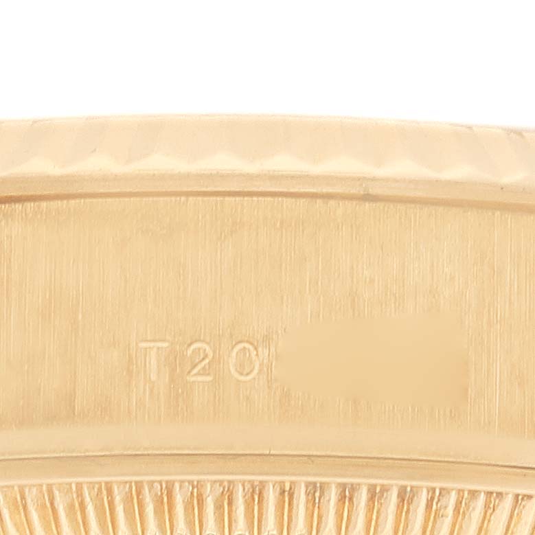 The image shows a close-up of the Rolex President 69178 Women
s Yellow Gold Champagne Dial 69178 Women
s Yellow Gold Champagne Dial model, focusing on a part of the case with engraving details.