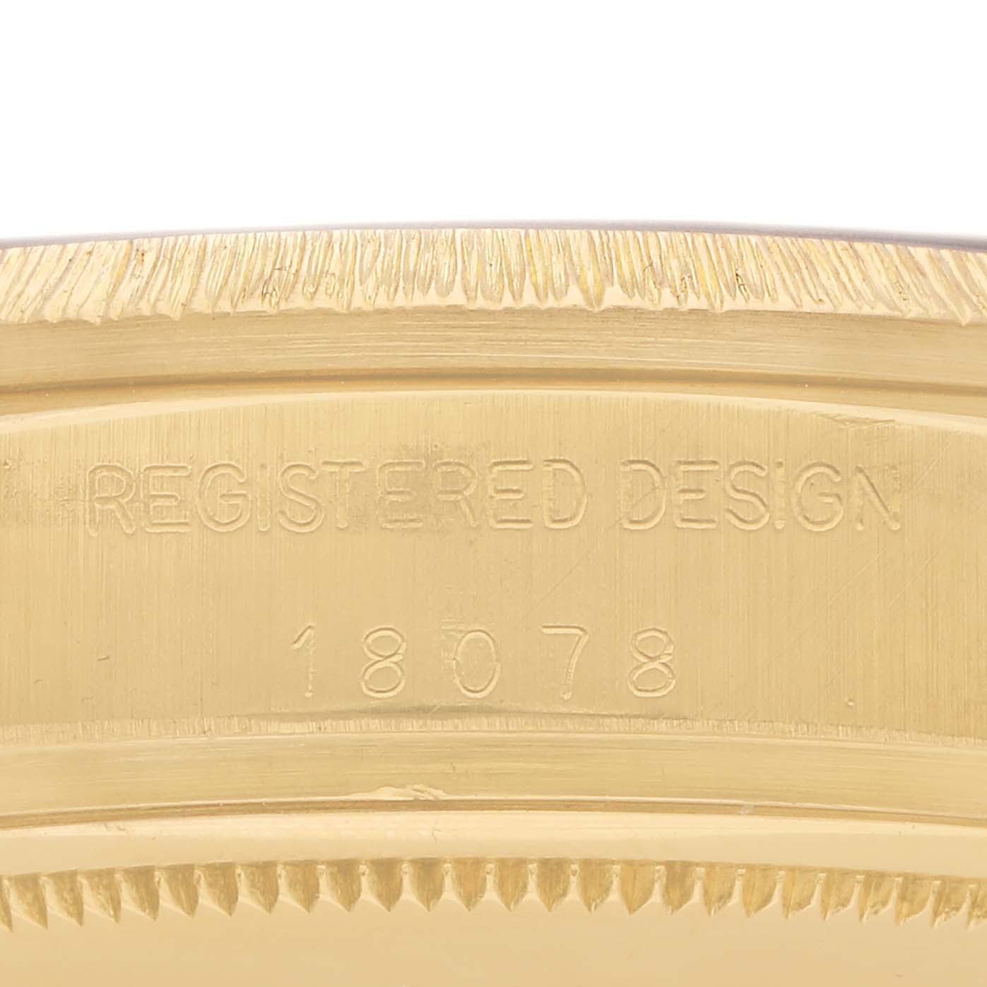 The image shows a close-up of the Rolex President 18078 Men
s Yellow Gold Brown Dial 18078 Men
s Yellow Gold Brown Dial model
s side, featuring the case with "REGISTERED DESIGN 18078" engraved.