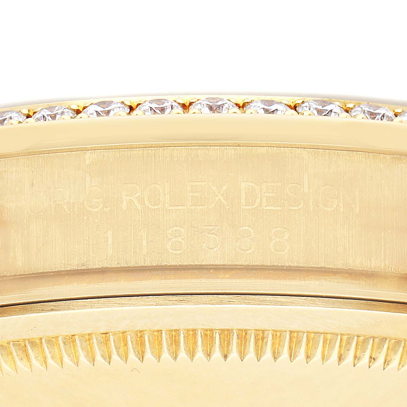 The image shows the side of the bezel and case of a Rolex President 118388 Men's Yellow Gold Mother of Pearl Dial 118388 Men's Yellow Gold Mother of Pearl Dial watch, featuring engraved details and diamond accents.
