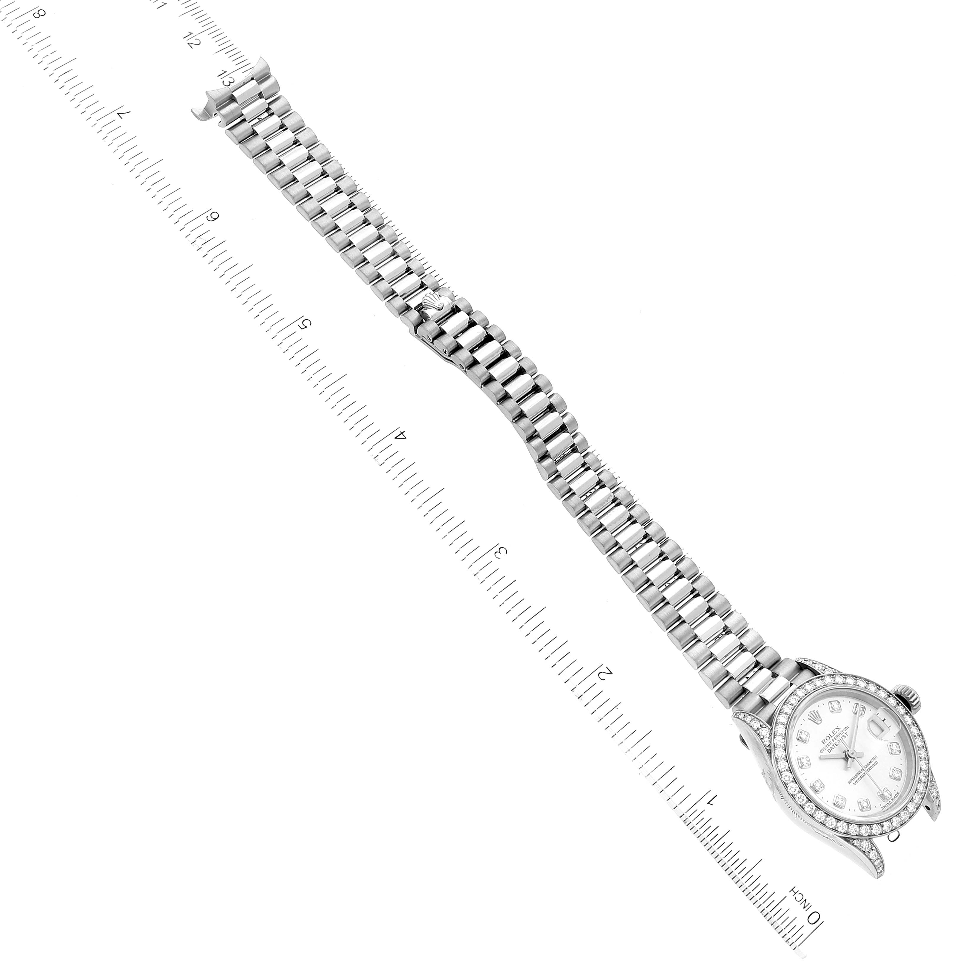 This image shows the Rolex President 79159 Women's White Gold Silver Dial 79159 Women's White Gold Silver Dial watch model laid flat with the dial and full bracelet visible next to a measurement ruler.