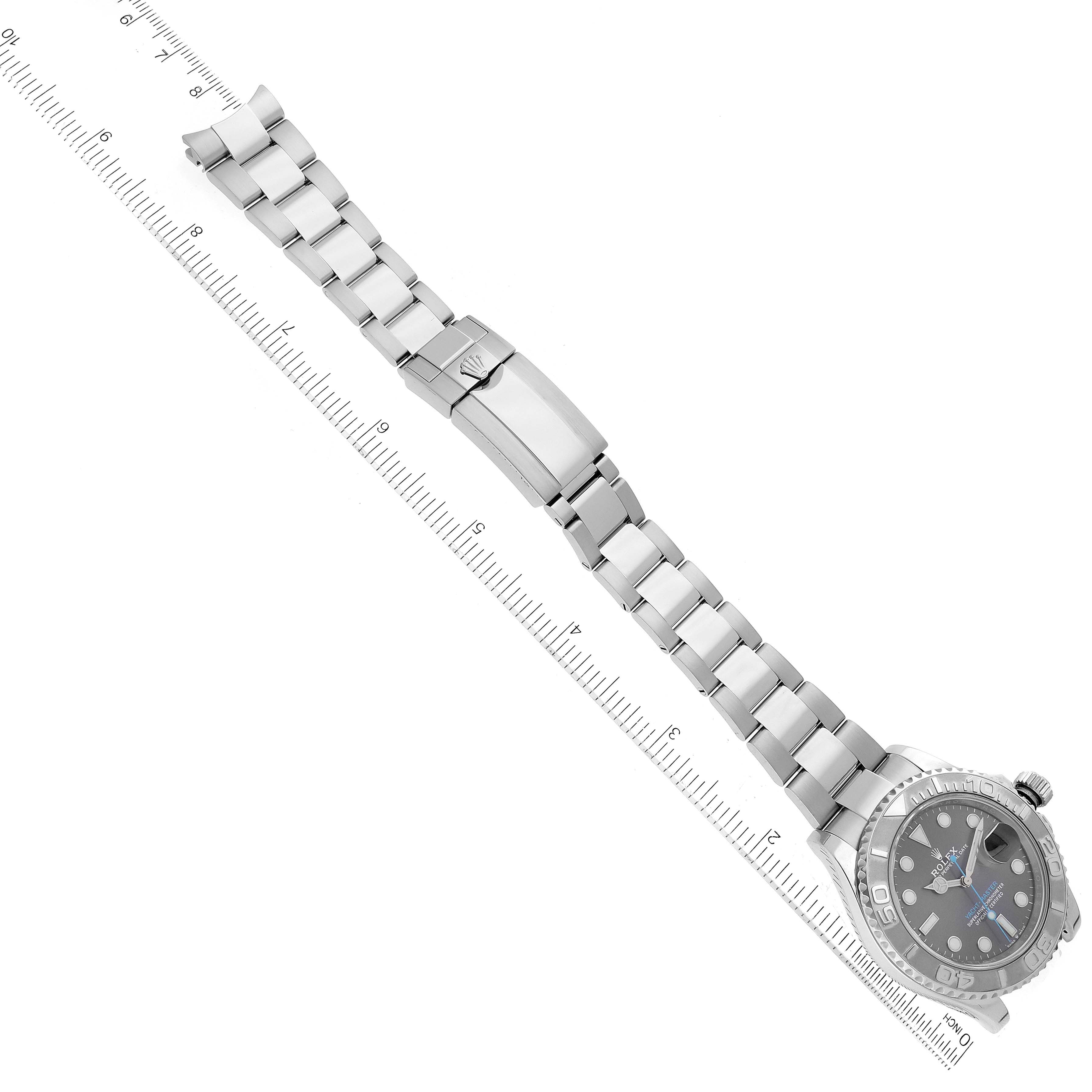 The image shows a top view of a Rolex Yacht-Master 126622 Men's Stainless Steel Grey Dial 126622 Men's Stainless Steel Grey Dial watch, featuring its face, bezel, and metal bracelet with a clasp, accompanied by a ruler.