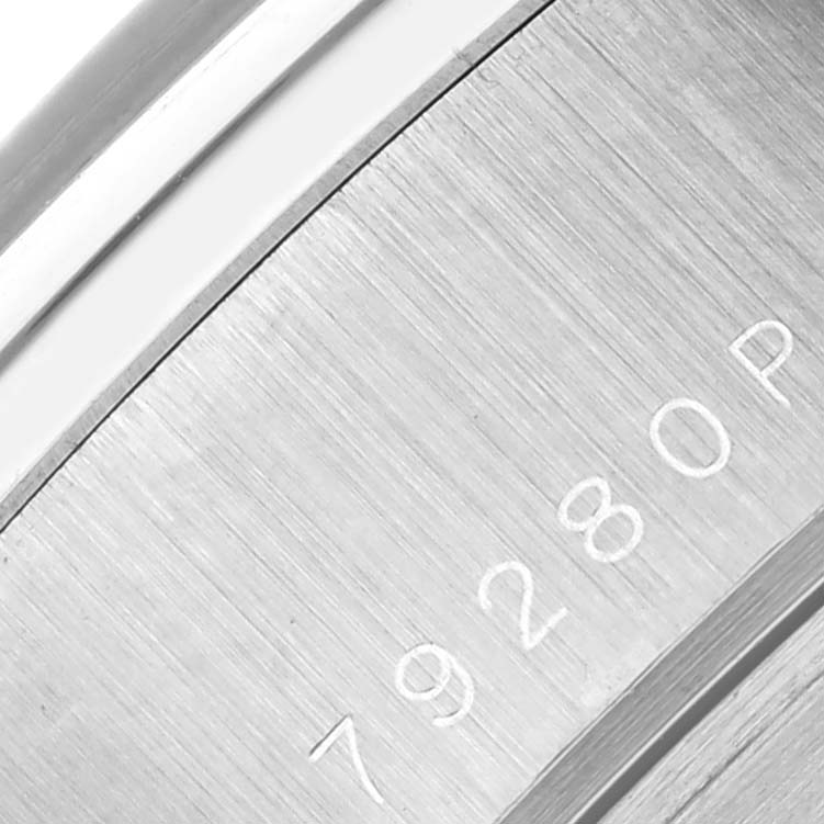 The image shows a close-up of the brushed metal back of the Tudor Tiger 79280 Men's Stainless Steel Red Dial 79280 Men's Stainless Steel Red Dial watch, revealing part of its engraved serial number.