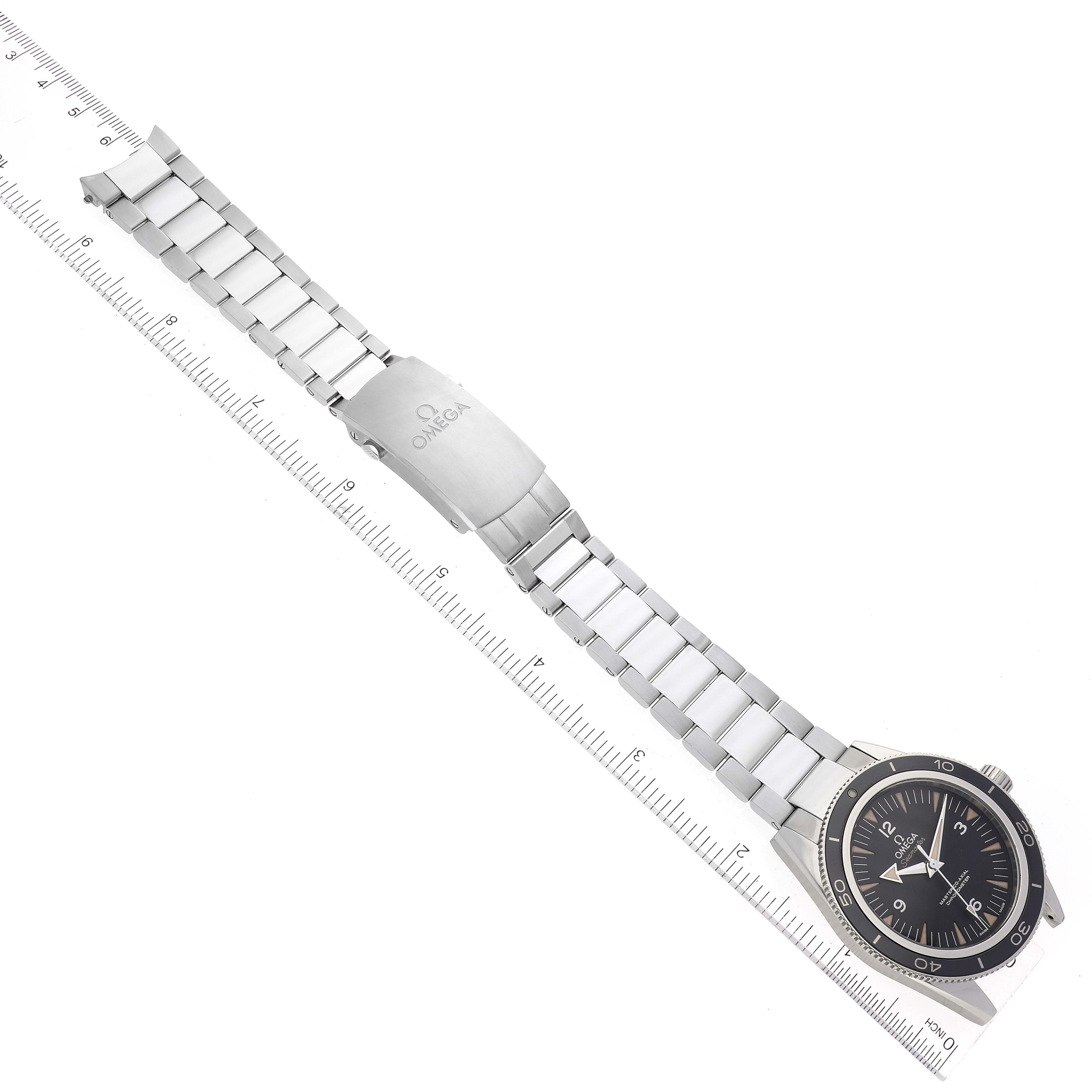 The Omega Seamaster 233.30.41.21.01.001 Men's Stainless Steel Black Dial 233.30.41.21.01.001 Men's Stainless Steel Black Dial watch is shown from a top-down angle, highlighting its face, bezel, and metal bracelet alongside a ruler.