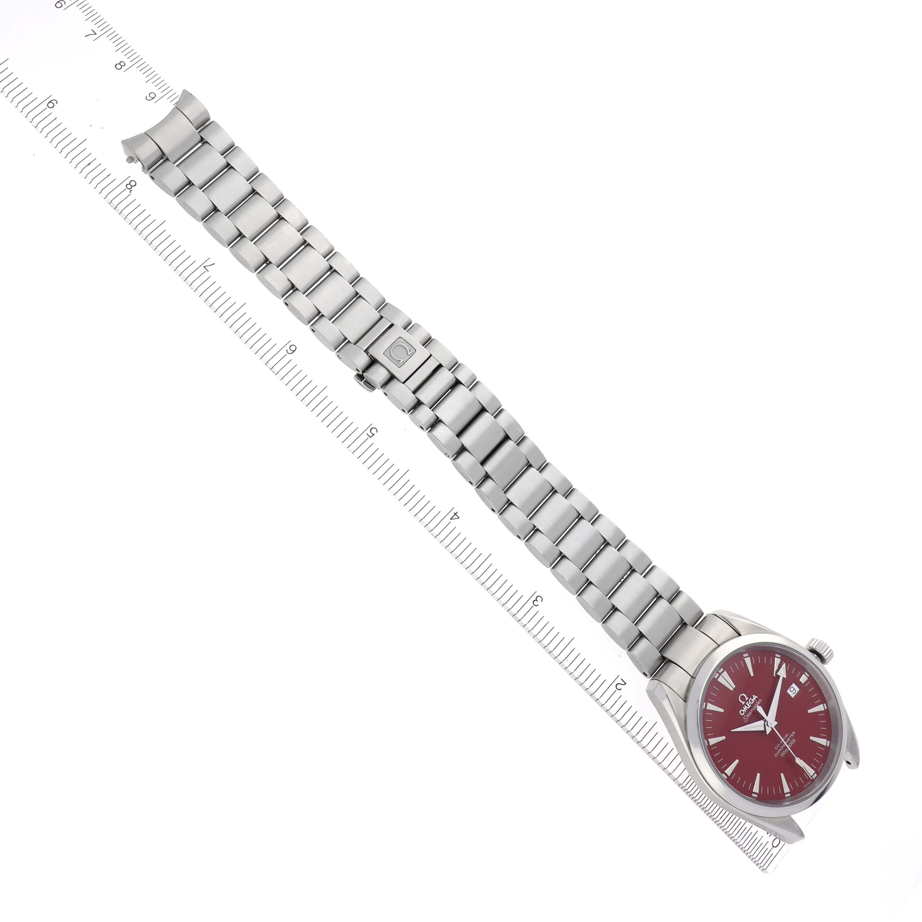 The Omega Aqua Terra 2503.60.00 Men
s Stainless Steel Red Dial 2503.60.00 Men
s Stainless Steel Red Dial watch is shown from a top-down angle, highlighting its red dial and full metal bracelet with a ruler for scale.