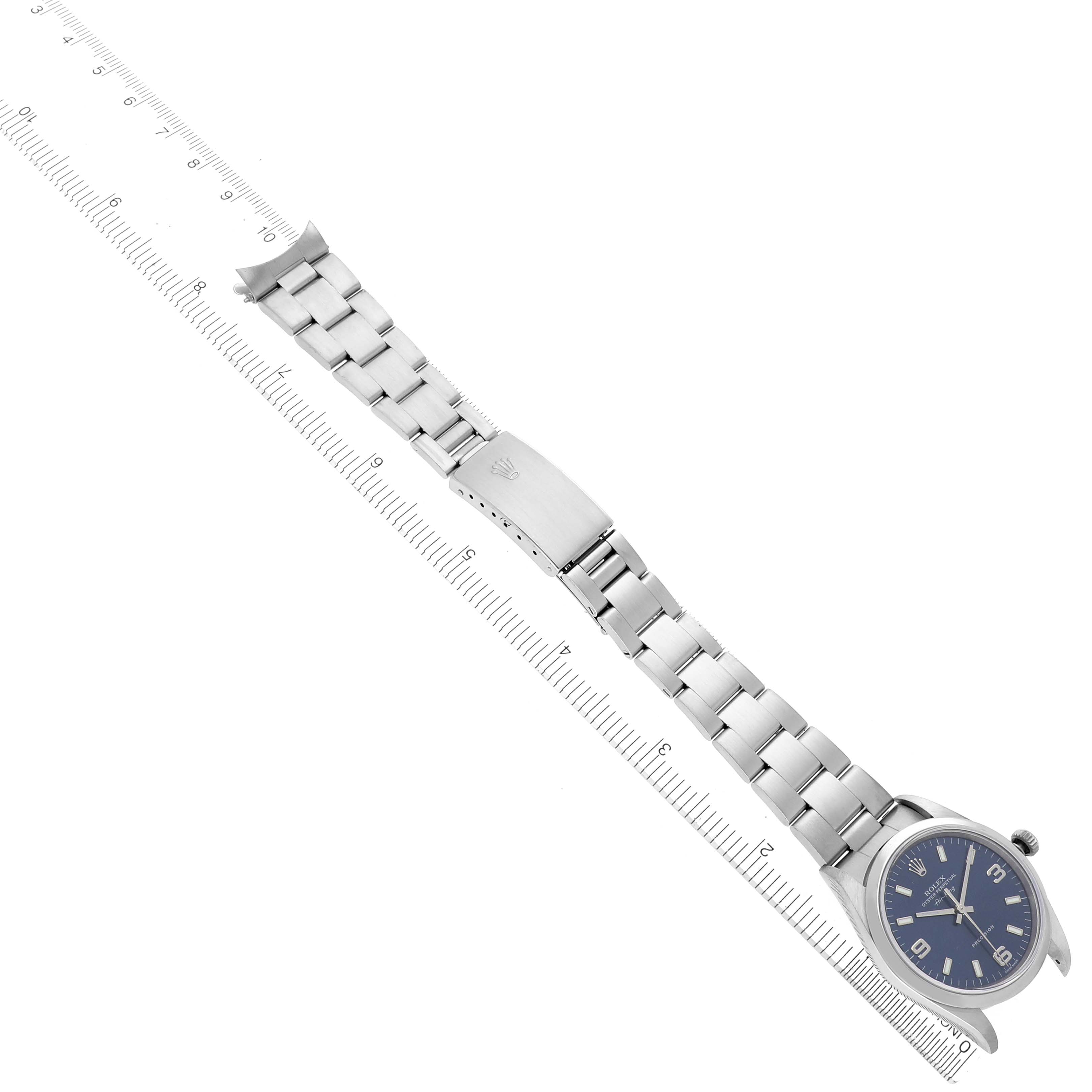 The Rolex Air-King 14000M Men's Stainless Steel Blue Dial 14000M Men's Stainless Steel Blue Dial watch is shown from above, displaying the face, bracelet, and clasp alongside a measuring scale.