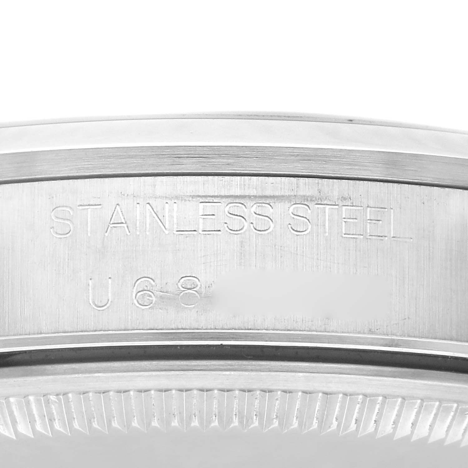 This image shows a close-up view of the case back edge of a Rolex Air-King 14000 Men's Stainless Steel Blue Dial 14000 Men's Stainless Steel Blue Dial watch, highlighting the serial number and "STAINLESS STEEL" engraving.