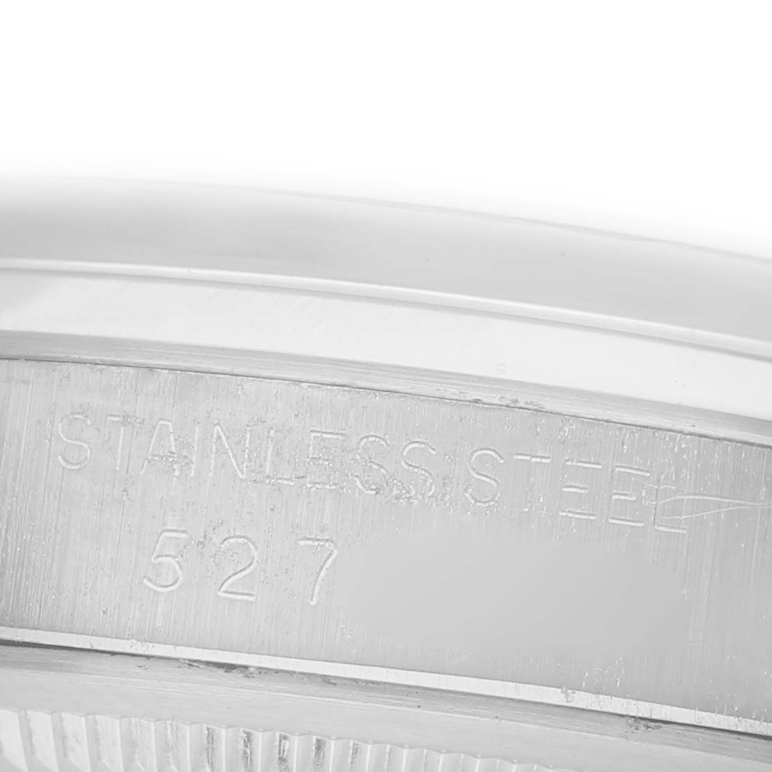 The image shows a close-up of the side of a Rolex Date 68587 Men's Stainless Steel Silver Dial 68587 Men's Stainless Steel Silver Dial model, highlighting the stainless steel case with engraving details.