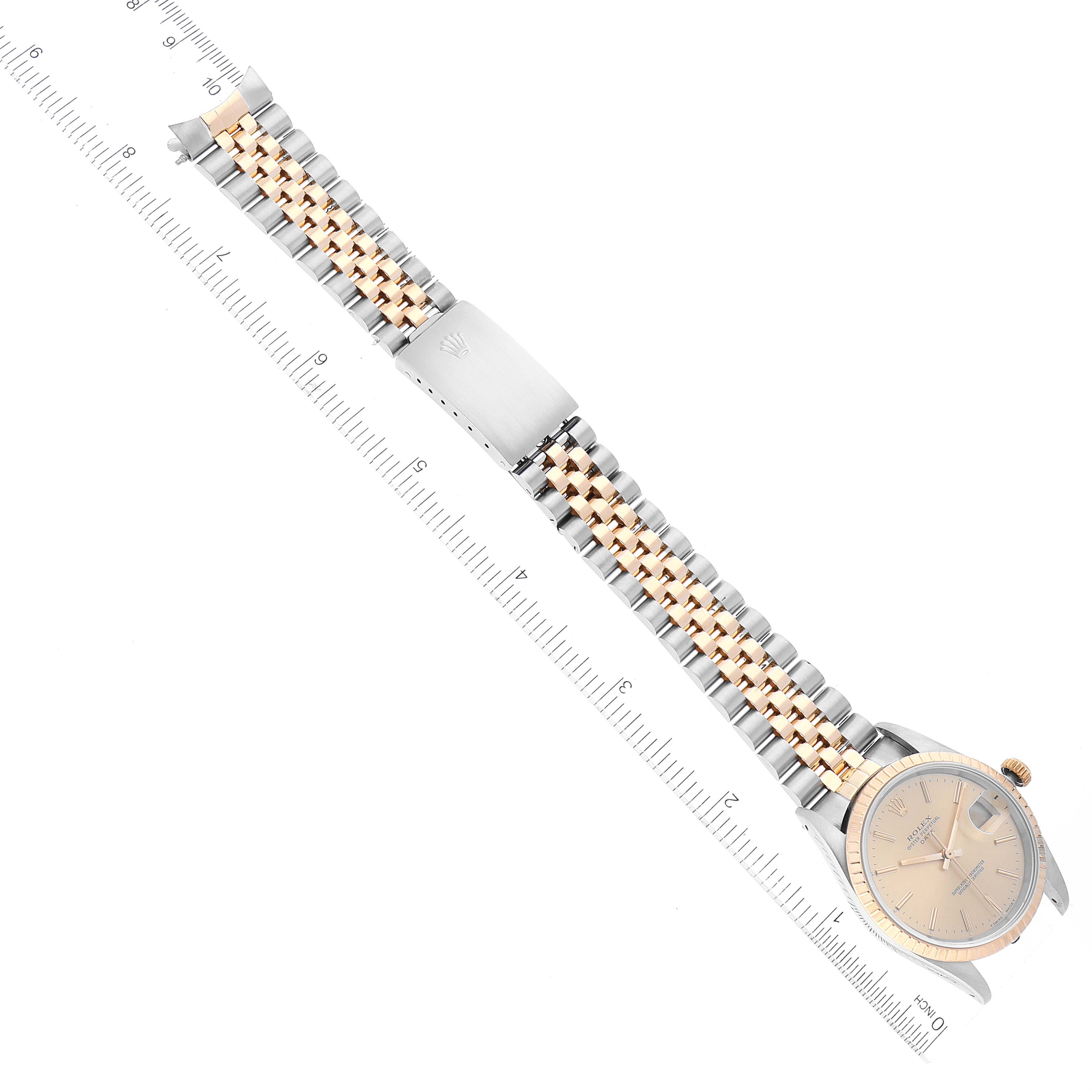 The image shows a Rolex Date 15223 Men's Steel and Gold (two tone) Champagne Dial 15223 Men's Steel and Gold (two tone) Champagne Dial model watch from a top-down angle, displaying its bracelet, clasp, and face with a ruler for scale.