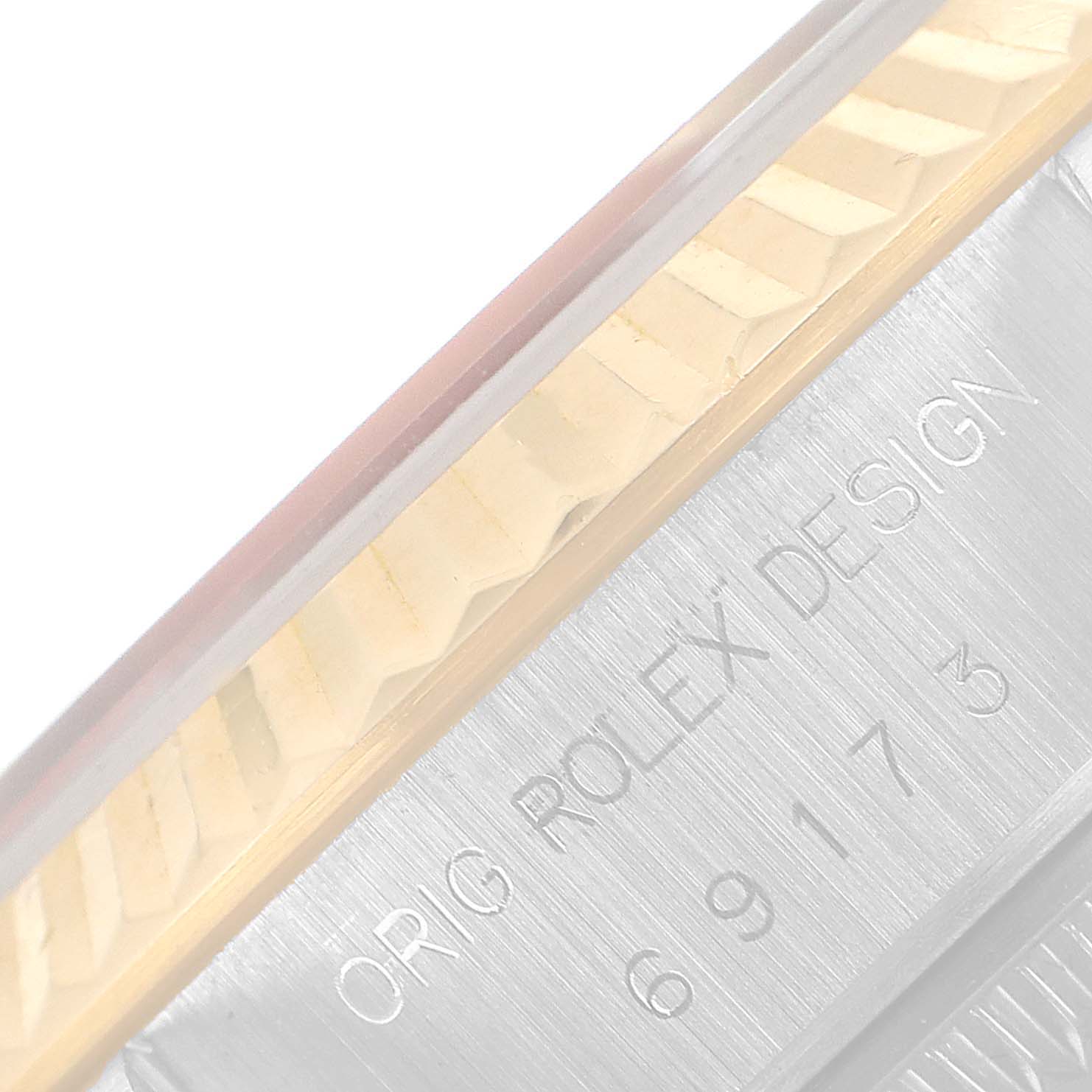 A close-up shot shows the side of a Rolex Datejust 69173 Women's Steel and Gold (two tone) Blue Dial 69173 Women's Steel and Gold (two tone) Blue Dial model case with "ORIG ROLEX DESIGN" and a fluted bezel.