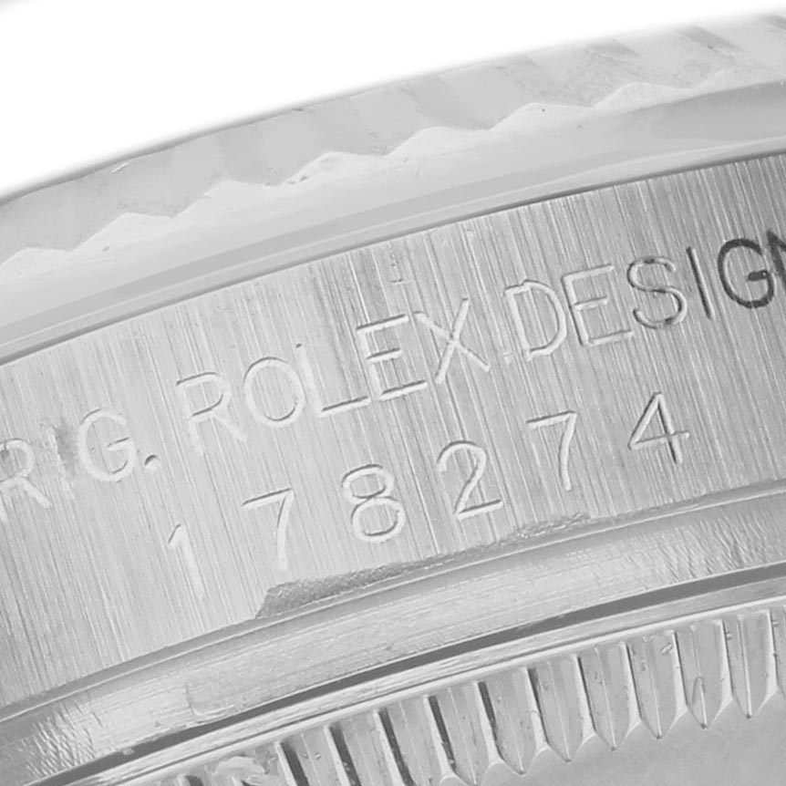 The image shows an angled close-up of the Rolex Mid-Size 178274 Women's Stainless Steel Mother of Pearl Dial 178274 Women's Stainless Steel Mother of Pearl Dial watch case, displaying engraved text and part of the bezel.