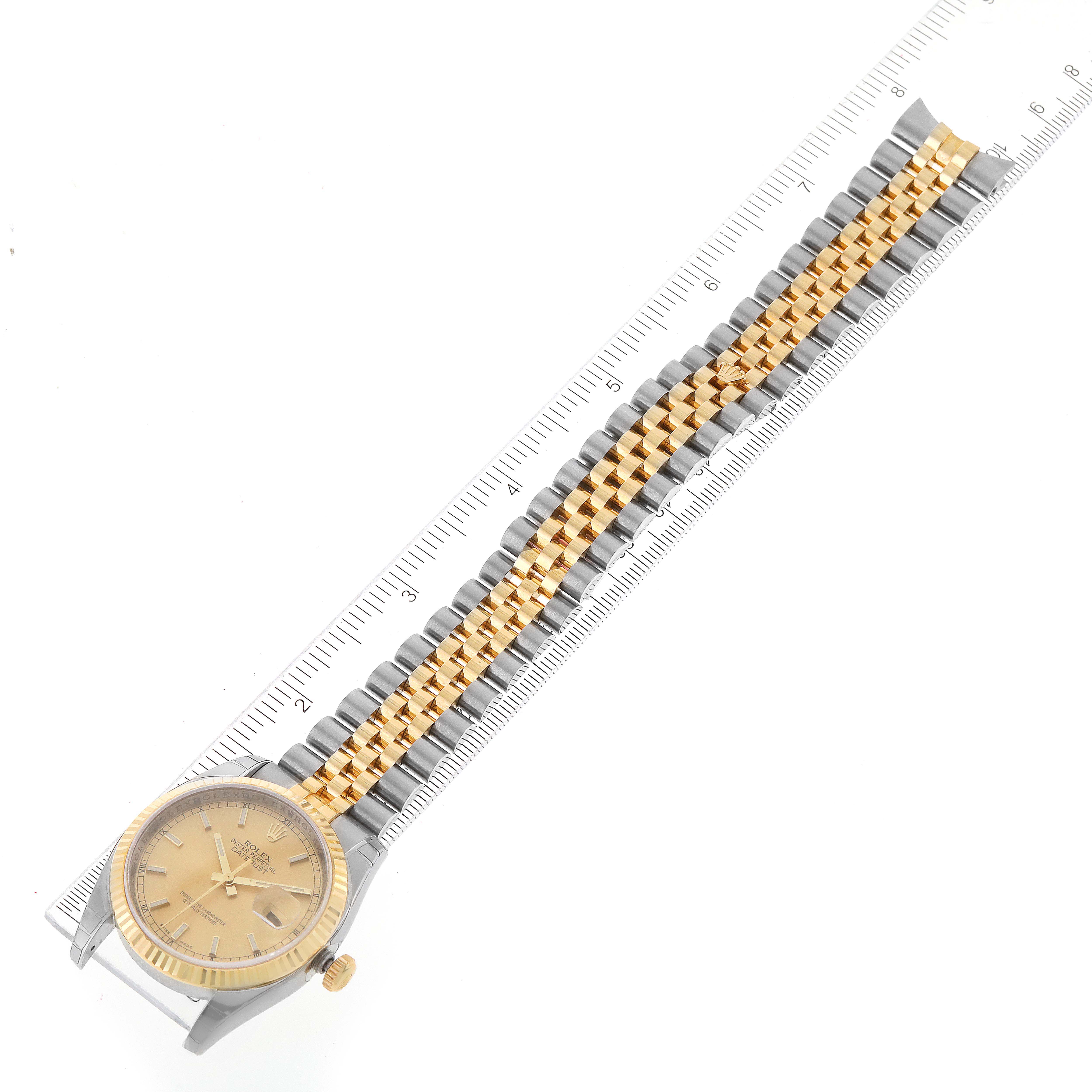 The image shows a Rolex Datejust 116233 Men's Steel and Gold (two tone) Champagne Dial 116233 Men's Steel and Gold (two tone) Champagne Dial watch with a silver and gold bracelet laid flat beside a ruler.