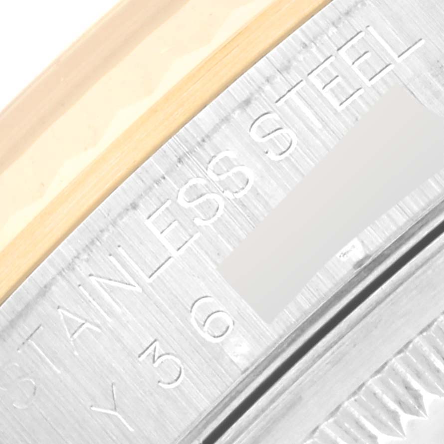 The image shows a close-up of the Rolex Datejust 16233 Men's Steel and Gold (two tone) Champagne Dial 16233 Men's Steel and Gold (two tone) Champagne Dial model's stainless steel case with partial text engraving.