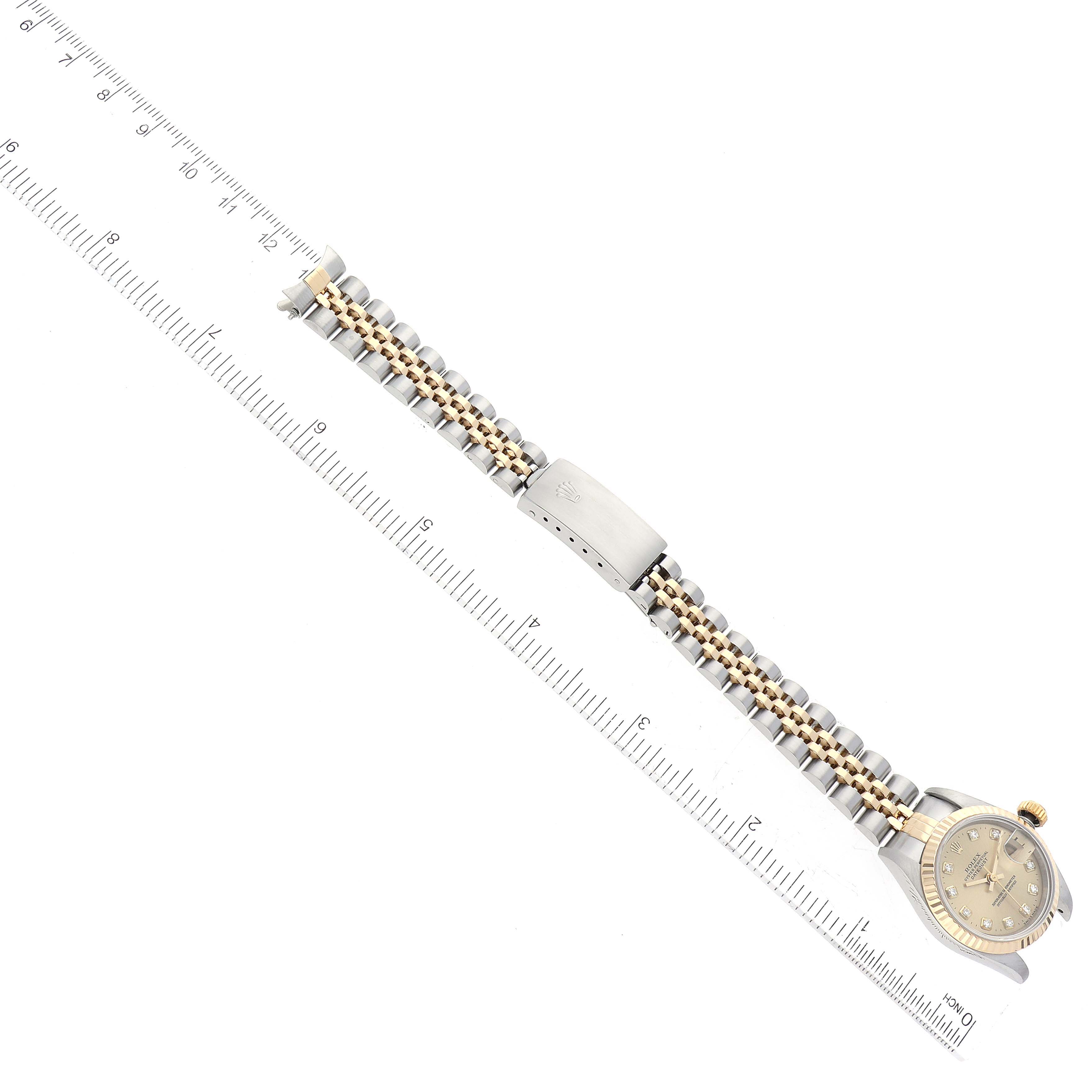 The image shows a Rolex Datejust 69173 Women's Steel and Gold (two tone) Champagne Dial 69173 Women's Steel and Gold (two tone) Champagne Dial watch laid flat, displaying the face, bracelet, and clasp next to a ruler for scale.
