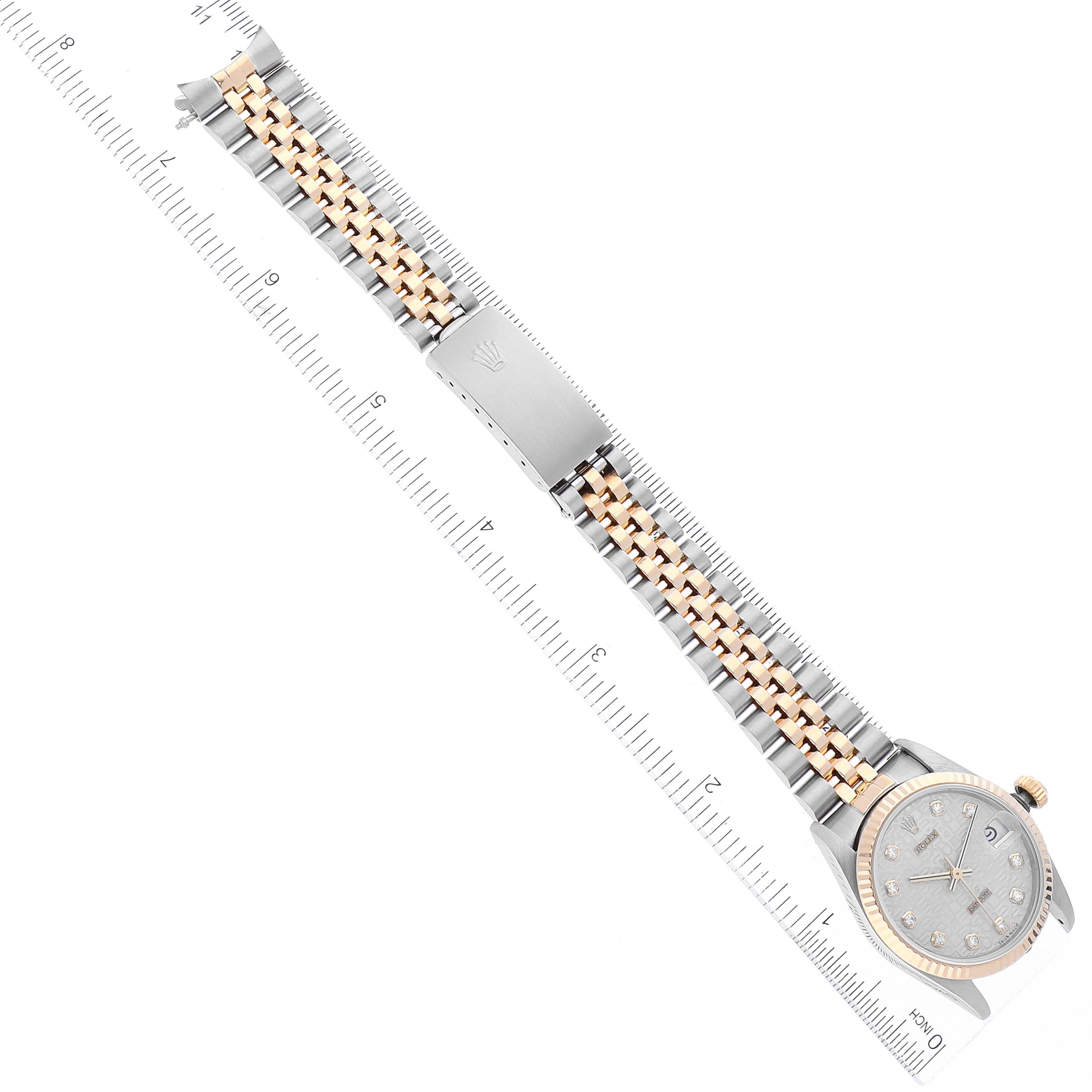 The Rolex Mid-Size 68273 Women's Steel and Gold (two tone) Silver Dial 68273 Women's Steel and Gold (two tone) Silver Dial watch is shown in a top-down angle, displaying its bracelet, clasp, and face, with a ruler for scale.