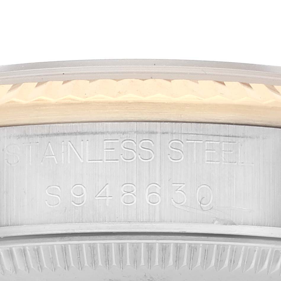 This image shows a close-up side view of the case of a Mid-Size Rolex watch, displaying 
Stainless Steel
 and a serial number.