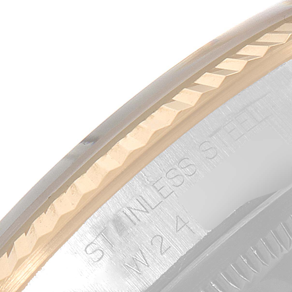 This close-up image of the Rolex Datejust 16233 Men's Steel and Gold (two tone) Champagne Dial 16233 Men's Steel and Gold (two tone) Champagne Dial watch shows the fluted bezel and part of the stainless steel case back.