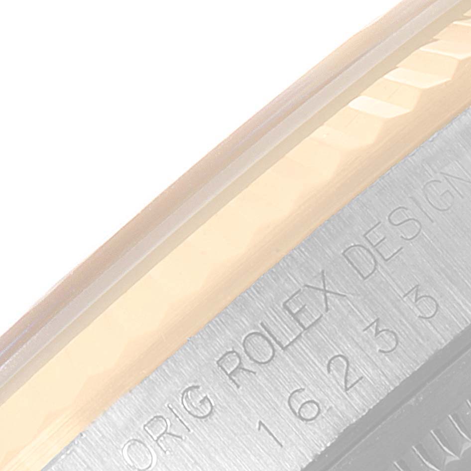 This close-up image shows the side of the Rolex Datejust 16233 Men's Steel and Gold (two tone) Champagne Dial 16233 Men's Steel and Gold (two tone) Champagne Dial watch, featuring part of the bezel and inscribed text on the case.
