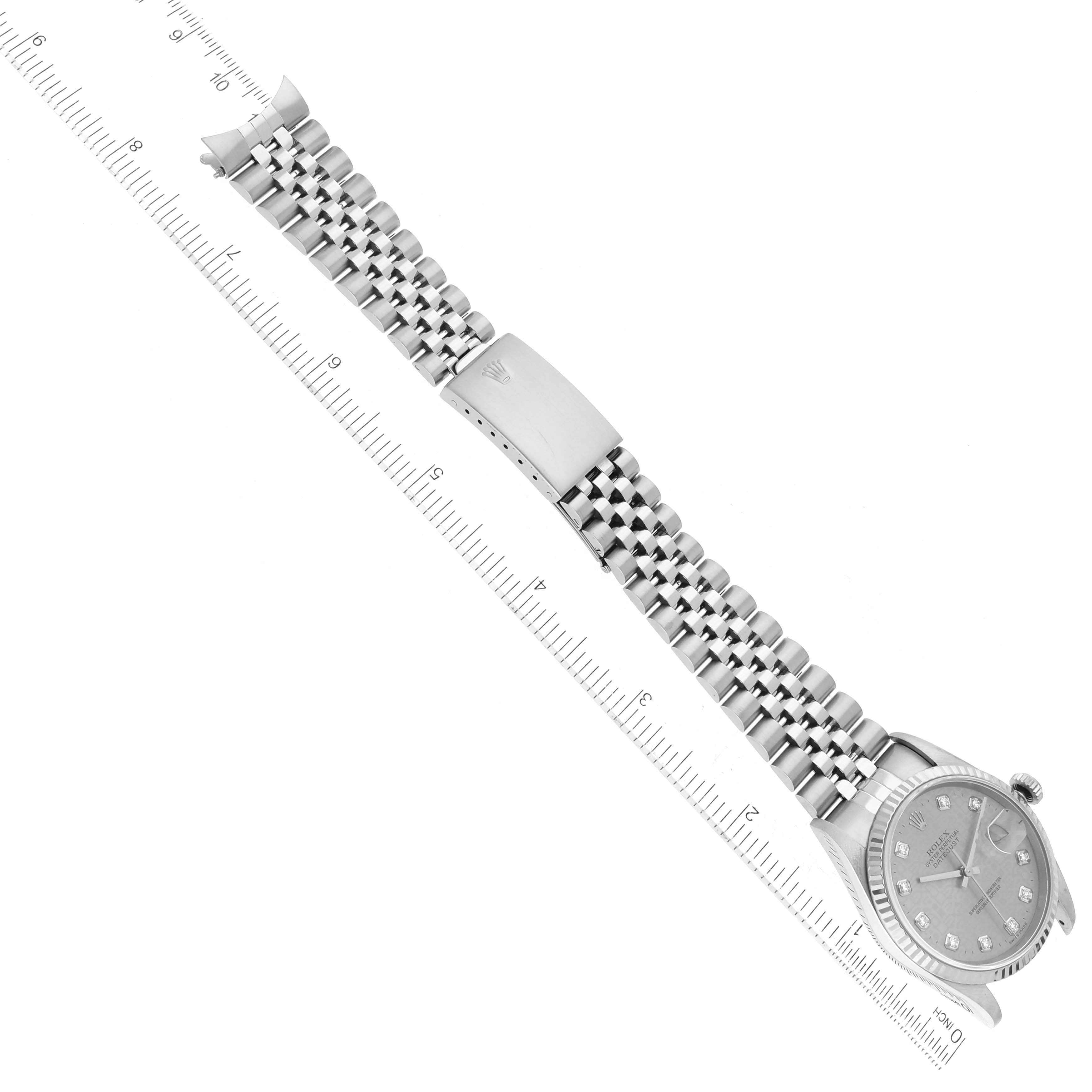 This image shows a Rolex Datejust 16234 Men
s Stainless Steel Silver Dial 16234 Men
s Stainless Steel Silver Dial watch at an angled top view, highlighting its dial, bezel, bracelet, and clasp with a ruler for scale.