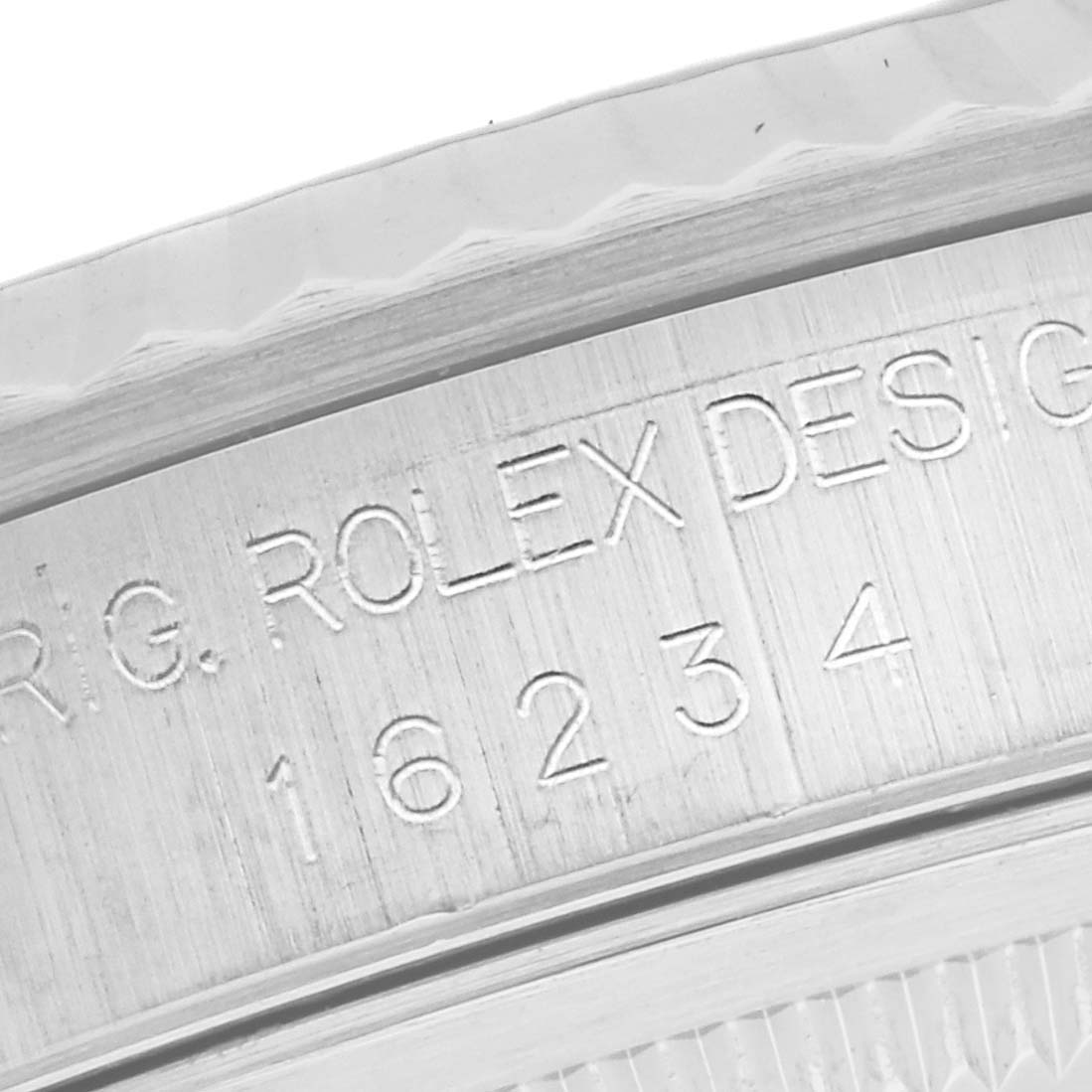 This close-up image shows the inner engraving on a Rolex Datejust 16234 Men's Stainless Steel Silver Dial 16234 Men's Stainless Steel Silver Dial, displaying the model number and "ROLEX DESIGN" text.