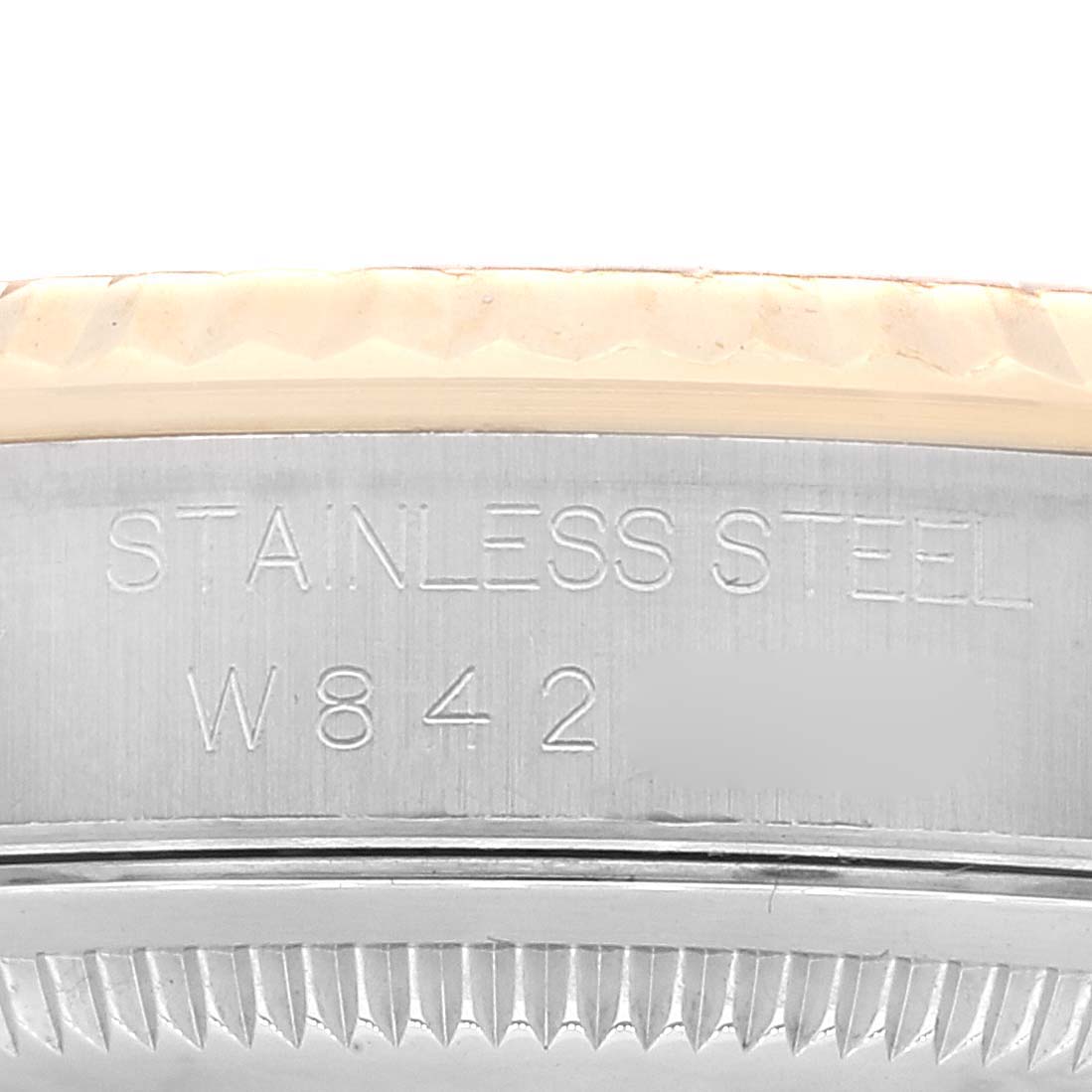 The image shows a close-up of the serial number and "STAINLESS STEEL" engraving on a Rolex Datejust 16233 Men's Steel and Gold (two tone) Champagne Dial 16233 Men's Steel and Gold (two tone) Champagne Dial model's case.