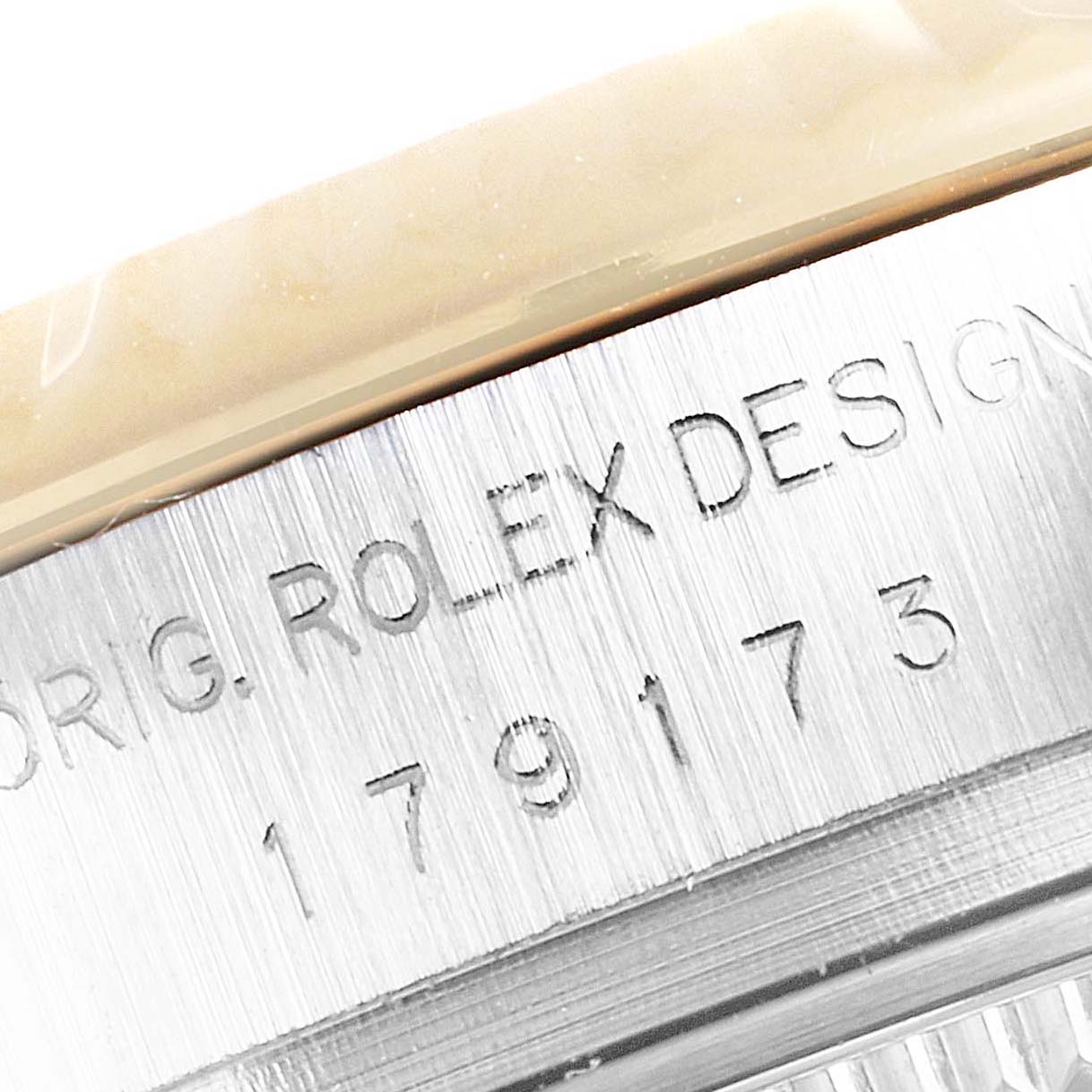 This image shows a macro shot of the engraved serial number on the side of a Rolex Datejust 179173 Women's Steel and Gold (two tone) Mother of Pearl Dial 179173 Women's Steel and Gold (two tone) Mother of Pearl Dial watch.
