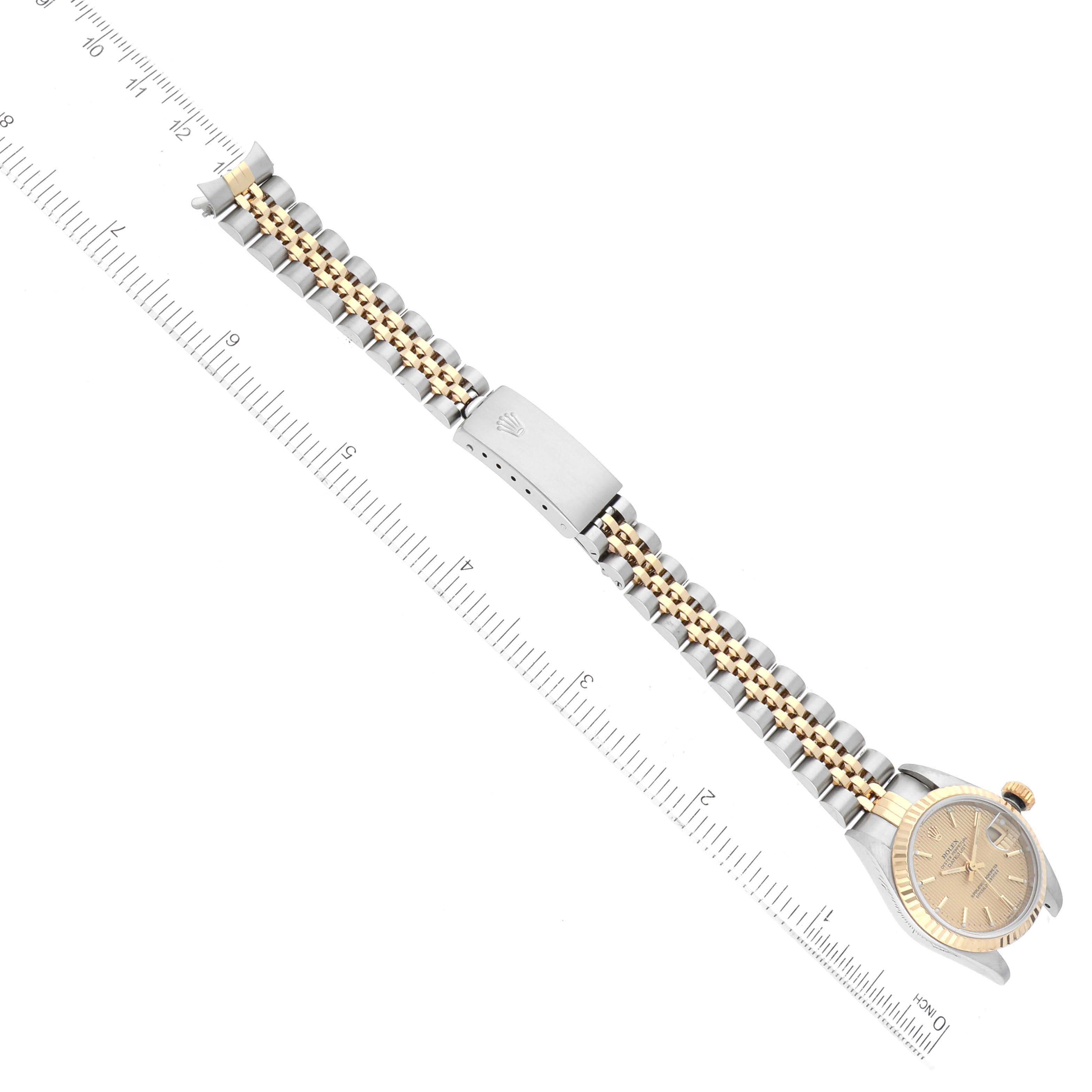 The image shows a top-view angle of a Rolex Datejust 79173 Women's Steel and Gold (two tone) Champagne Dial 79173 Women's Steel and Gold (two tone) Champagne Dial watch, featuring the bracelet and clasp alongside a ruler for scale.