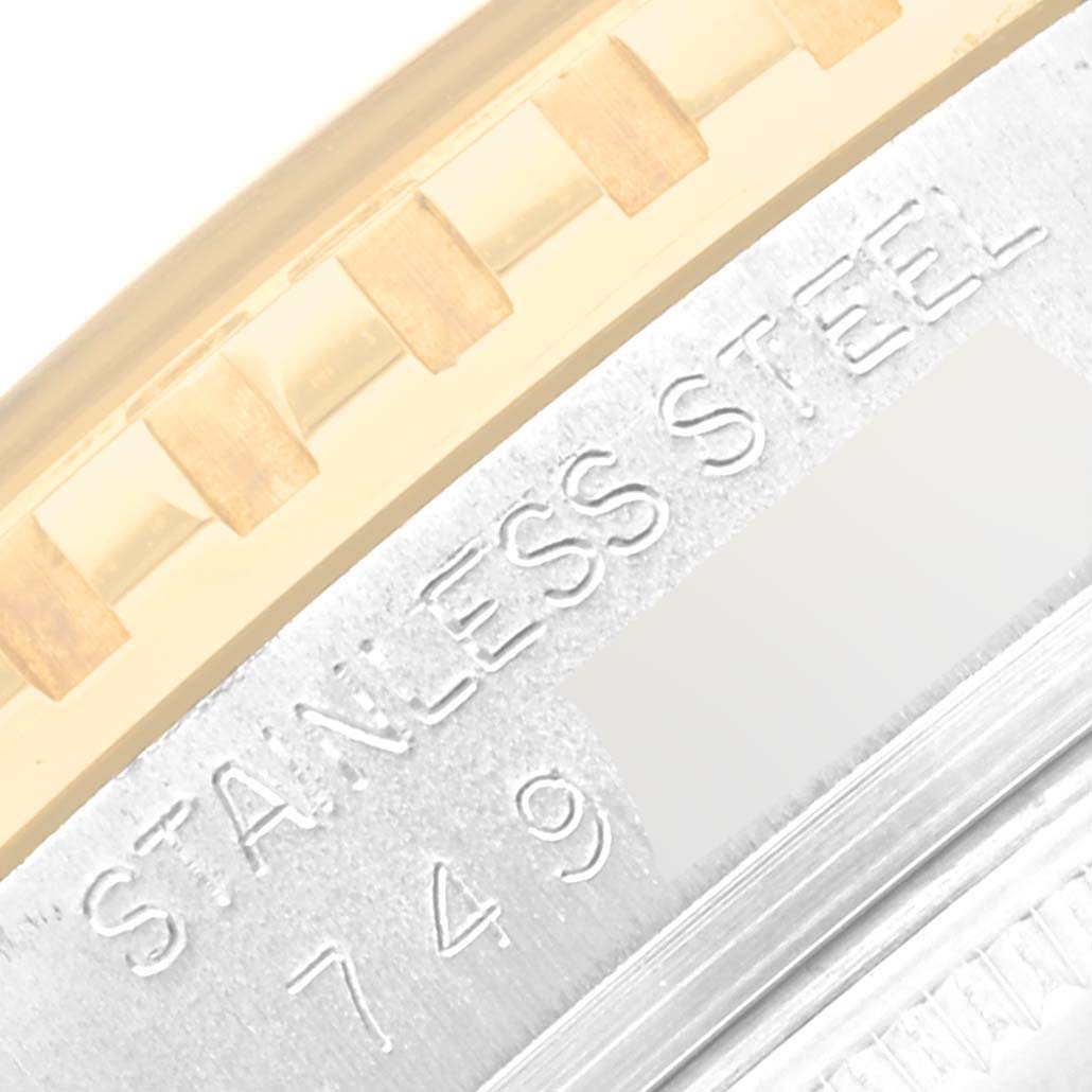 This image shows a close-up of the engraved stainless steel and gold bezel part of a Vintage Collection model by Rolex.