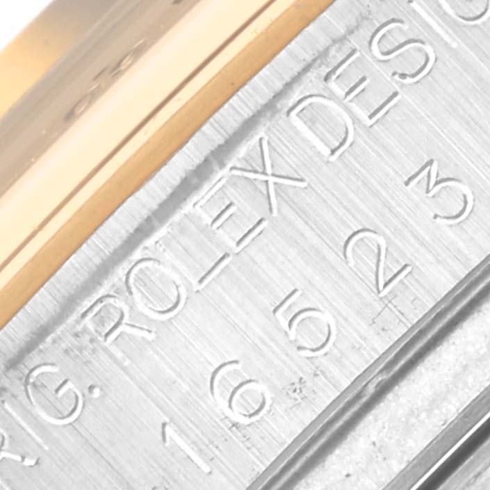 The image shows a close-up of the engraved outer edge of the bezel on a Rolex Daytona 16523 Men's Steel and Gold (two tone) Black Dial watch.