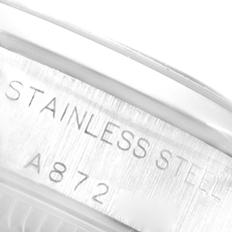 This close-up image shows the engraved text on the case back of a Rolex Oyster Perpetual 76080 Women's Stainless Steel Blue Dial 76080 Women's Stainless Steel Blue Dial watch indicating "STAINLESS STEEL."