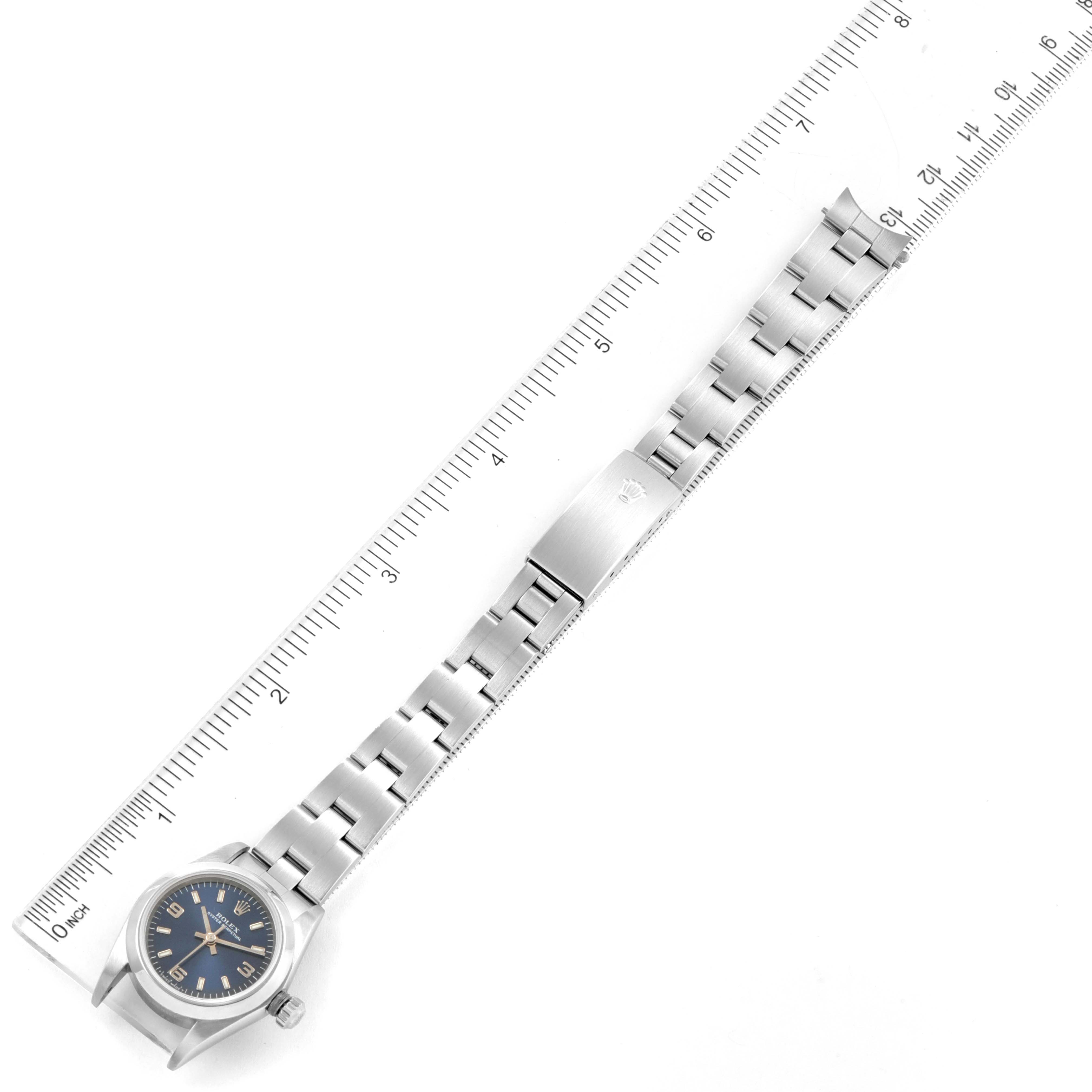 The image shows a top-down view of a Rolex Oyster Perpetual 76080 Women's Stainless Steel Blue Dial 76080 Women's Stainless Steel Blue Dial with its stainless steel bracelet measured against a ruler.