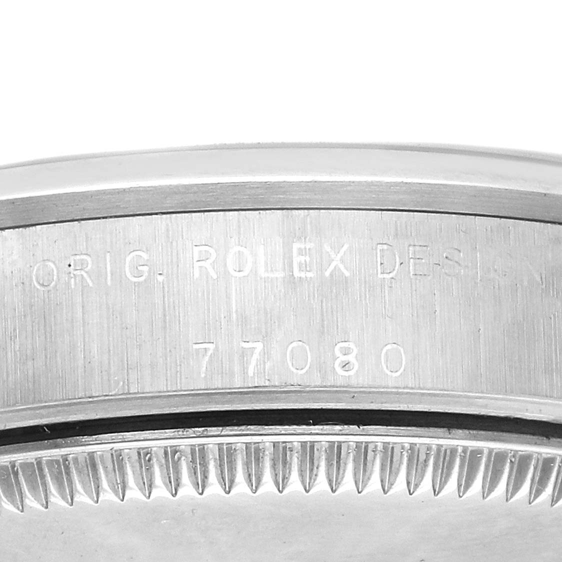 The image shows a close-up of the side edge of a Rolex Mid-Size 77080 Women's Stainless Steel Black Dial 77080 Women's Stainless Steel Black Dial watch, highlighting the engravings and bezel teeth.