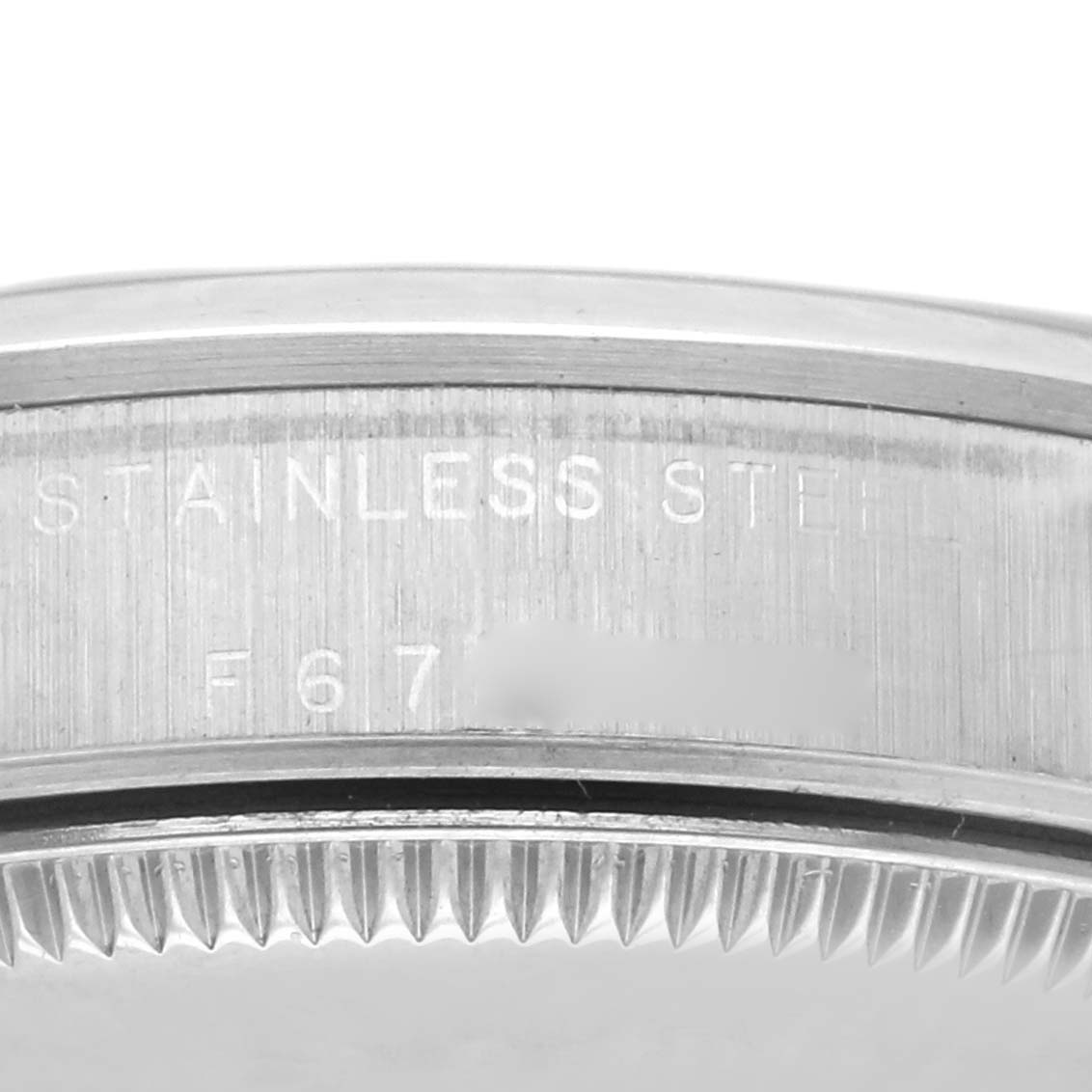 The image shows a close-up of the case's edge and bezel teeth of a Rolex Mid-Size 77080 Women's Stainless Steel Black Dial 77080 Women's Stainless Steel Black Dial watch, featuring "STAINLESS STEEL" engraving.